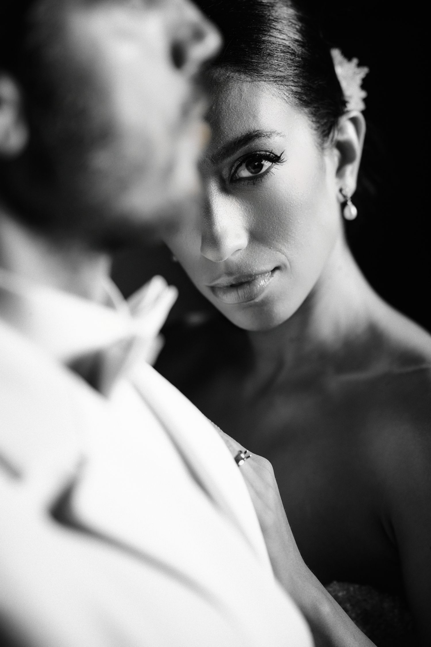 Black and white wedding portraits with dramatic lighting highlighting elegant details.