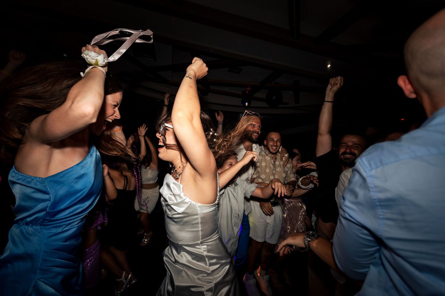 Energetic crowd dancing and celebrating at a nighttime party event.