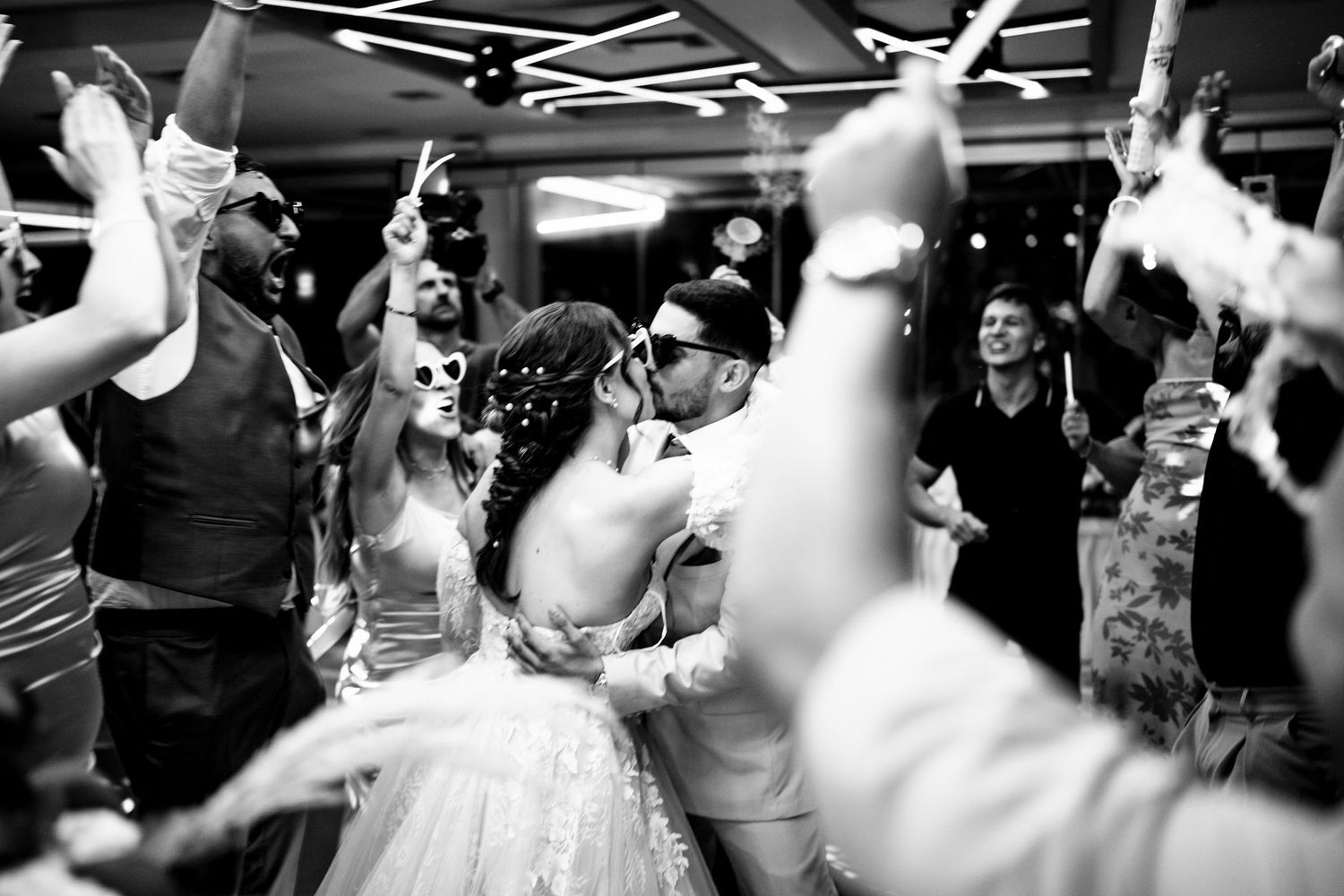 Lively wedding reception dance floor with guests celebrating in black and white.