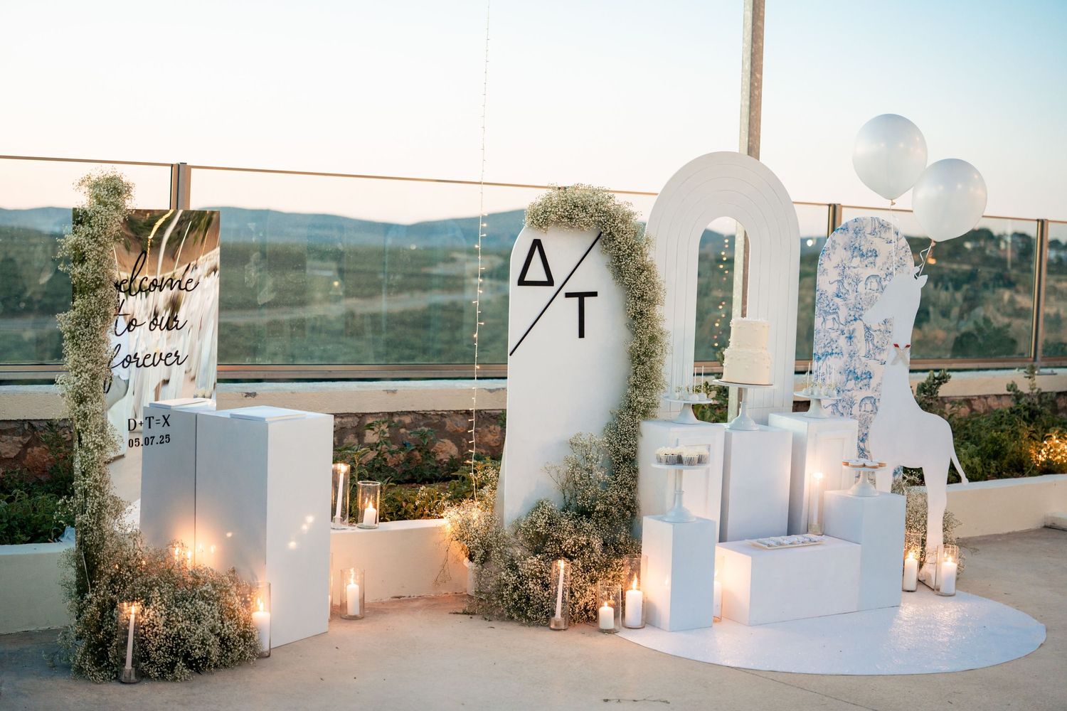 White Mediterranean-style wedding venue with candles and decorative elements at sunset.