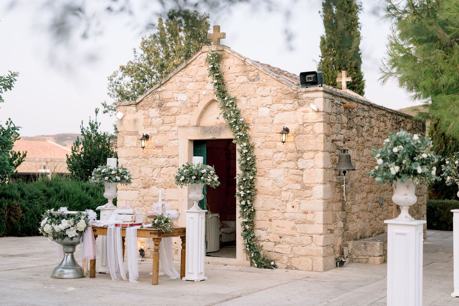 A rustic stone building decorated with floral arrangements and wedding decor.