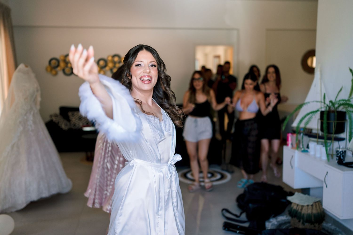 Group celebrating in a bridal boutique with raised hands and excited gestures.