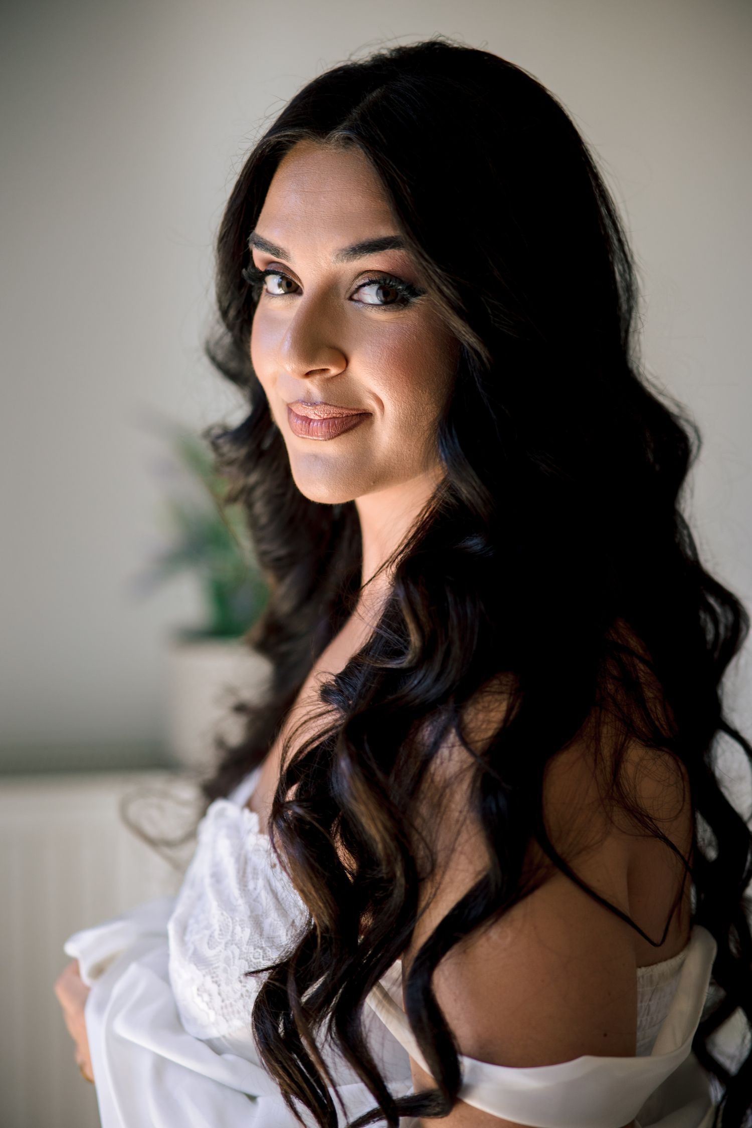Artistic bridal portrait with soft lighting and flowing dark hair.
