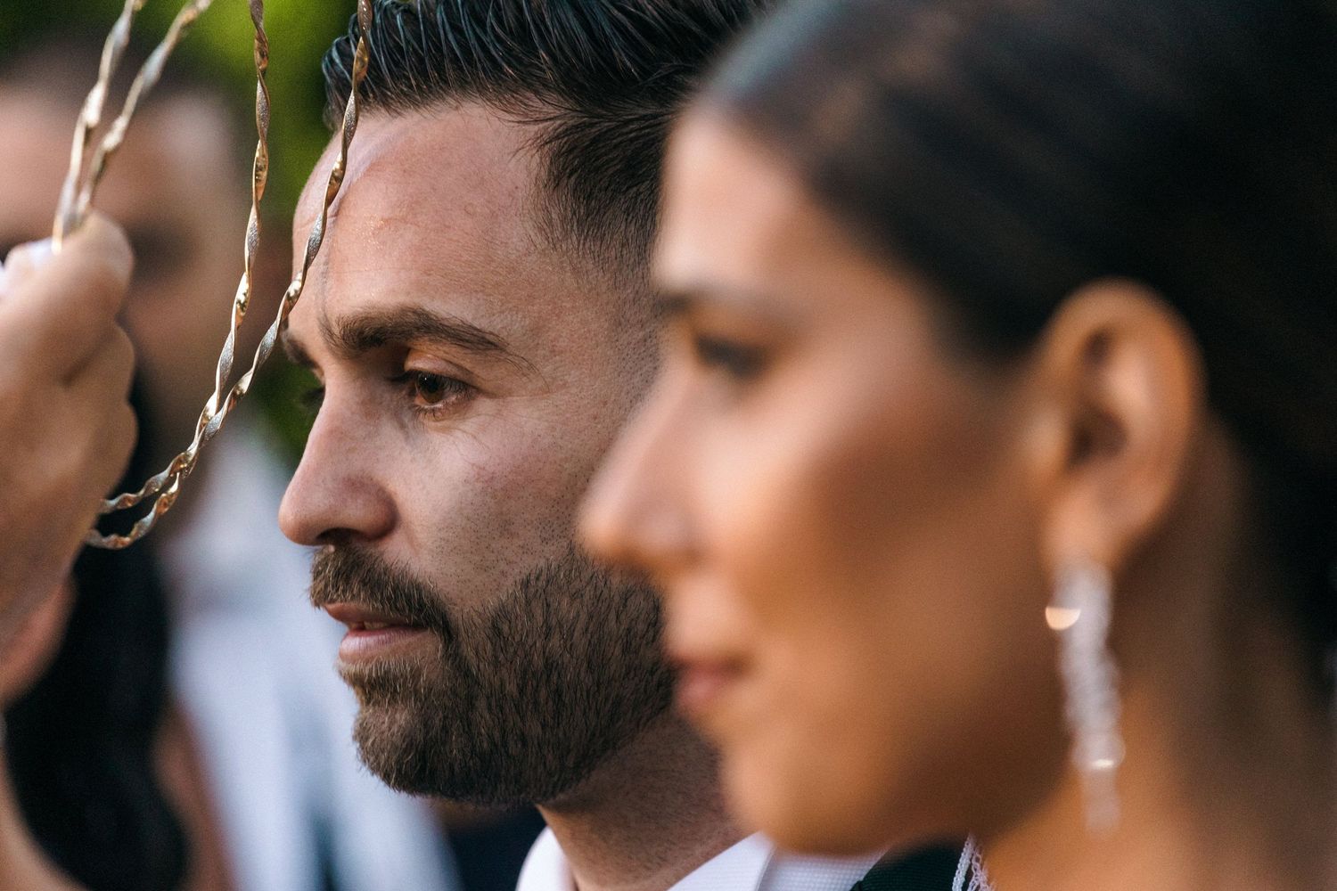 Artistic side profile portrait of wedding couple outdoors.