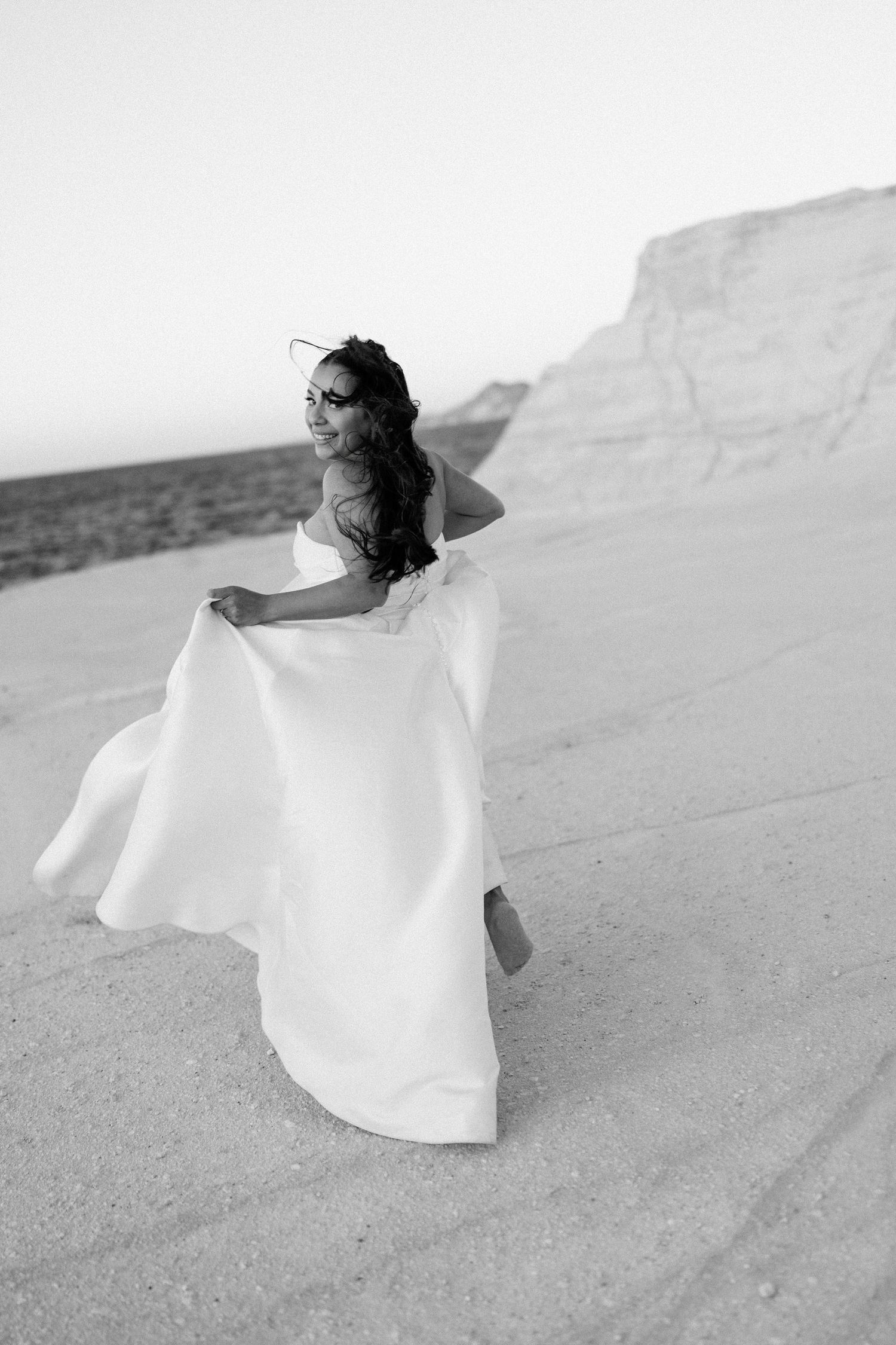 Flowing white dress movement captured against natural limestone backdrop.