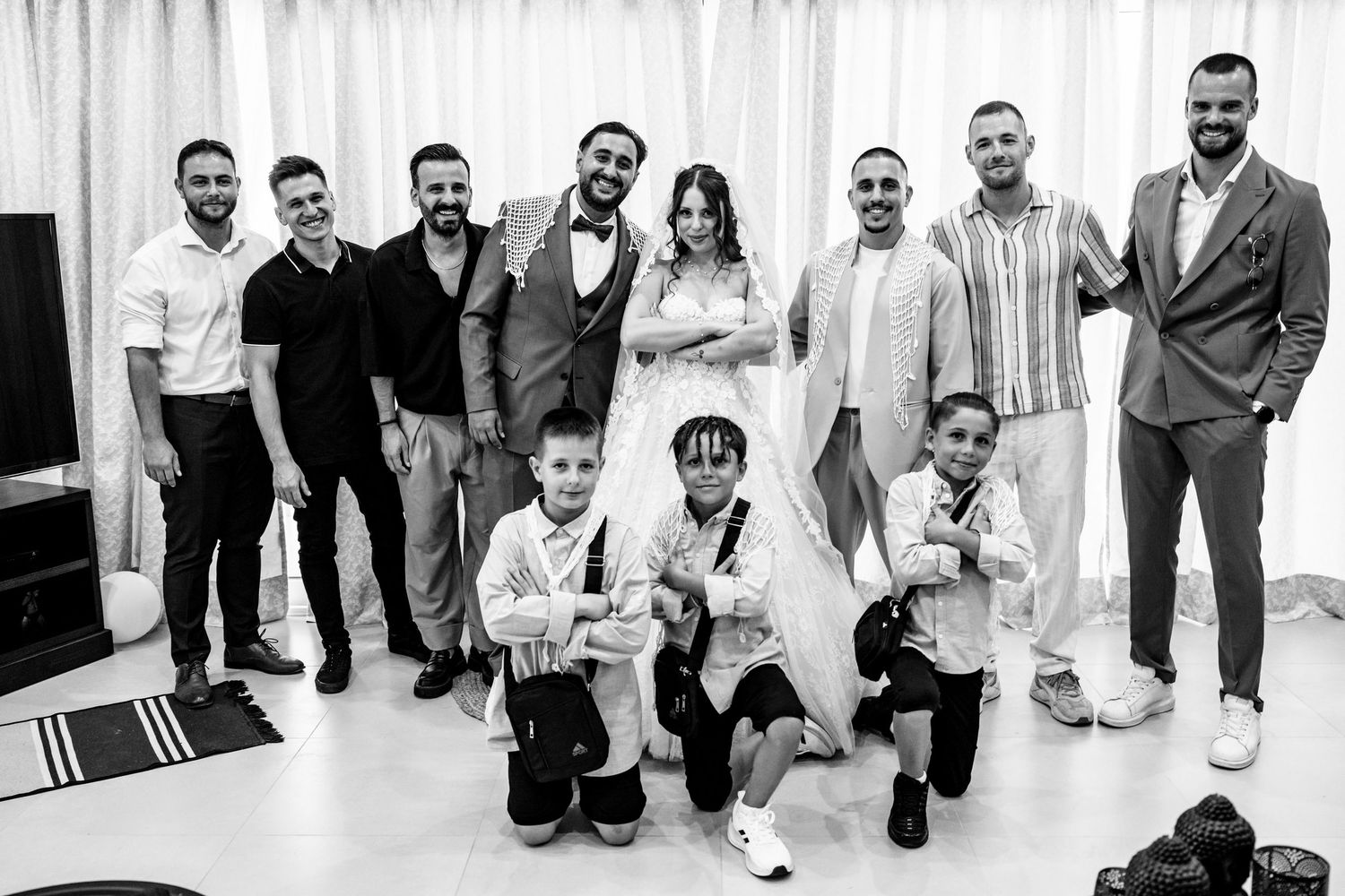 Wedding party poses together in black and white photo with casual yet stylish attire.