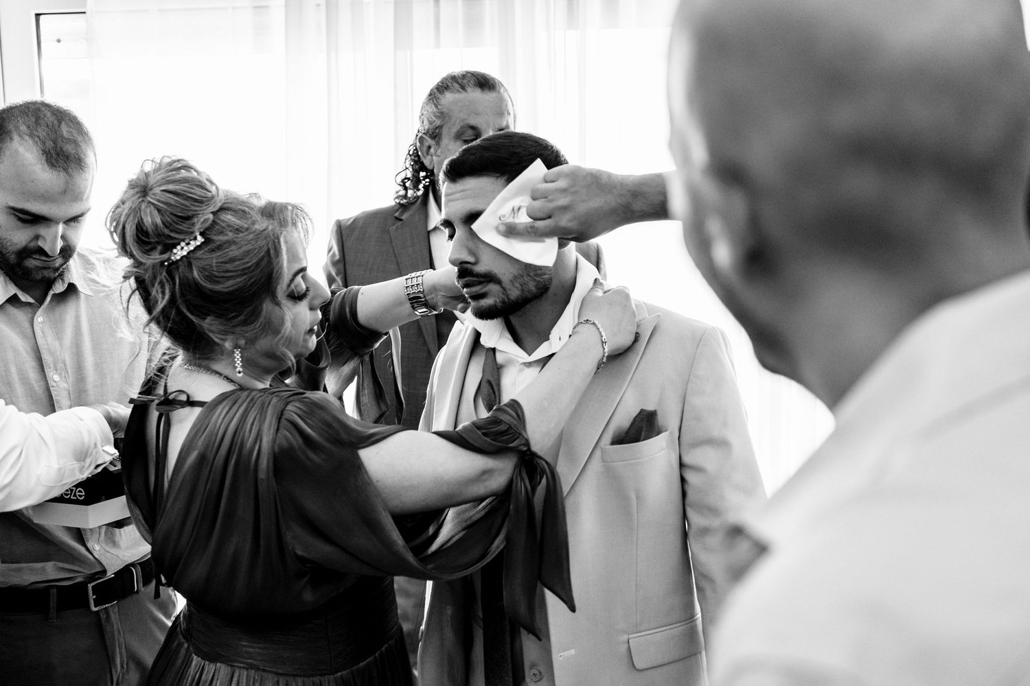 Black and white candid shots of wedding preparations with people getting ready.