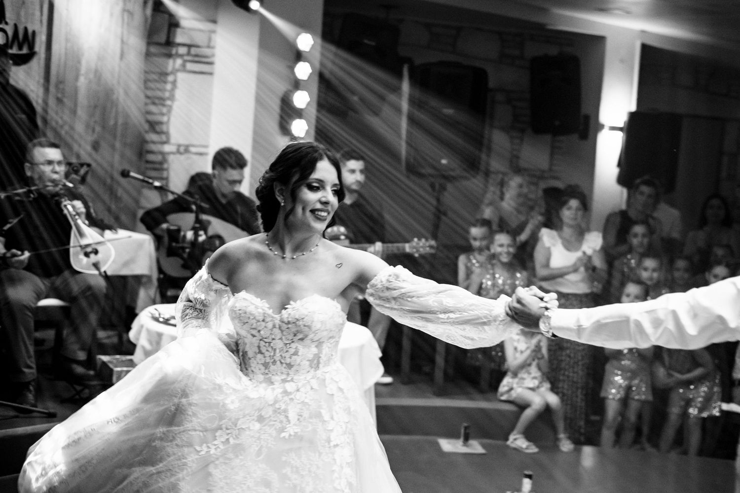 Wedding guests watch as couple performs their first dance in reception venue.