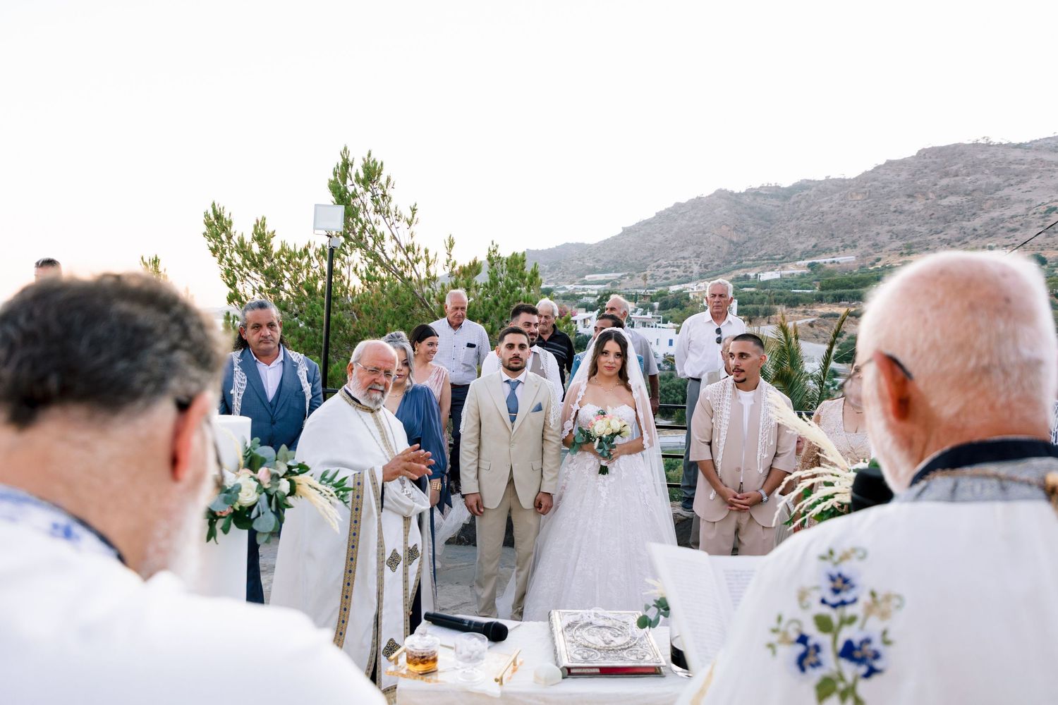 Wedding guests gathered outdoors with mountain scenery and natural decor.