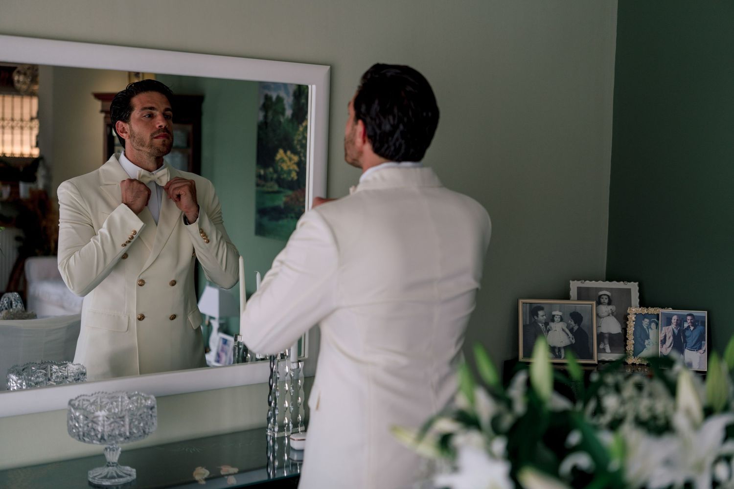 Getting ready scene reflected in mirror with formal white attire.
