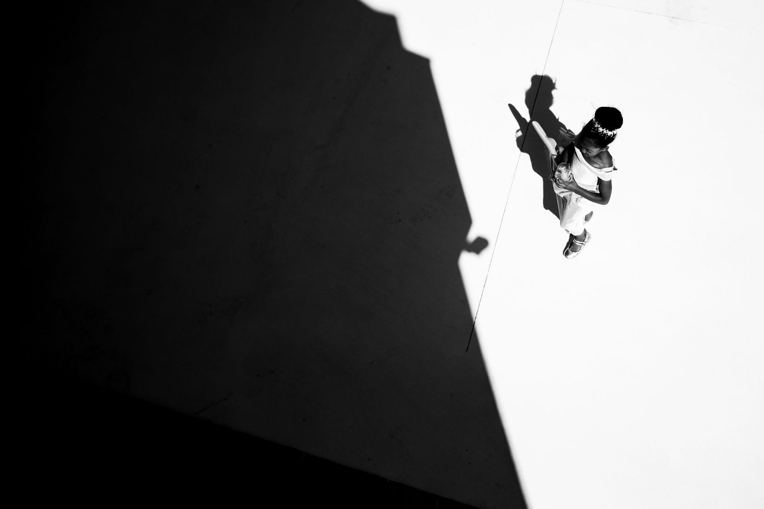 Dramatic black and white silhouettes of rock climbers ascending a steep wall.