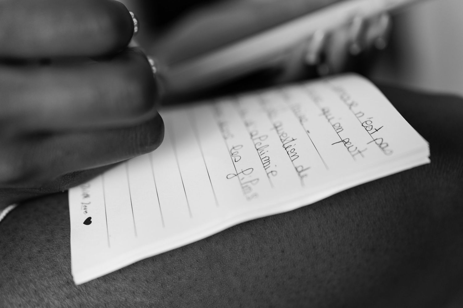 Hand writing on a piece of paper in black and white.