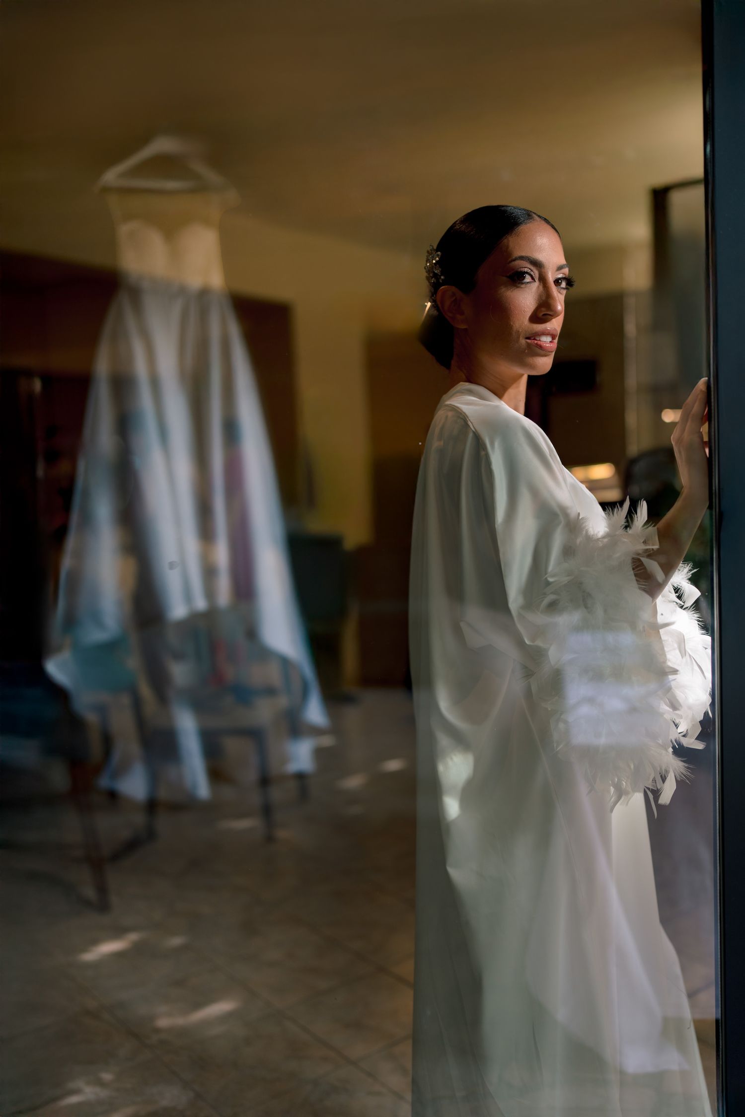Silhouette of wedding preparations through a window with soft lighting.