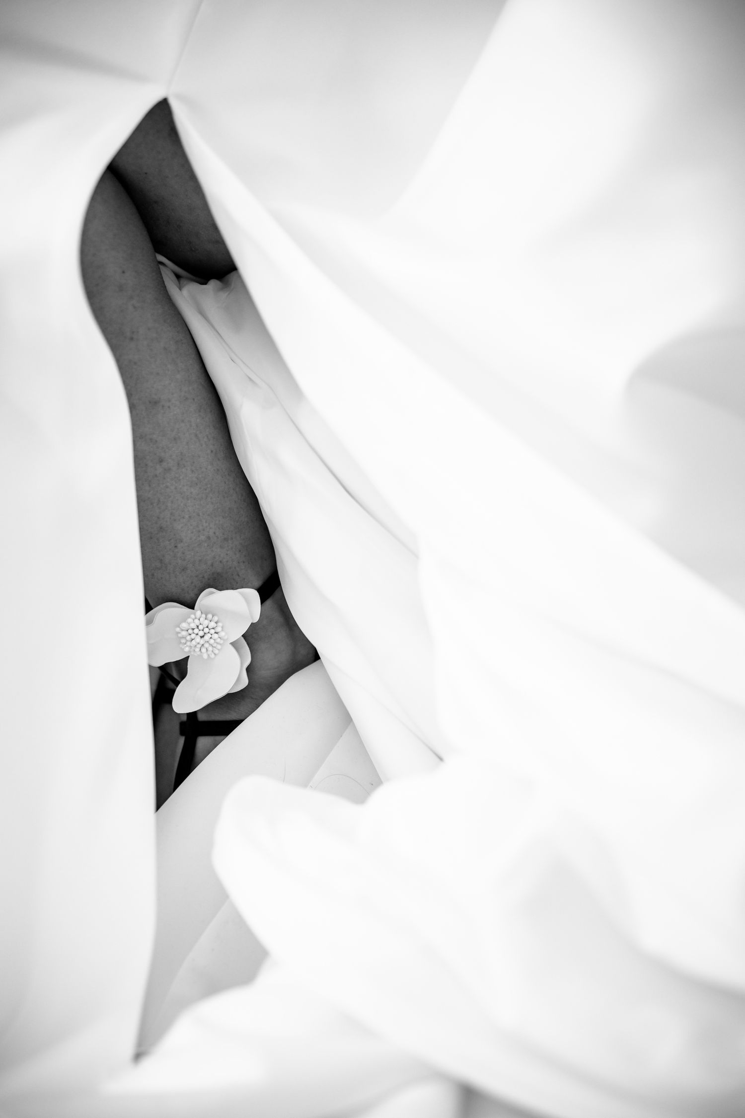 Close-up details of white wedding dress fabric and delicate lace details.