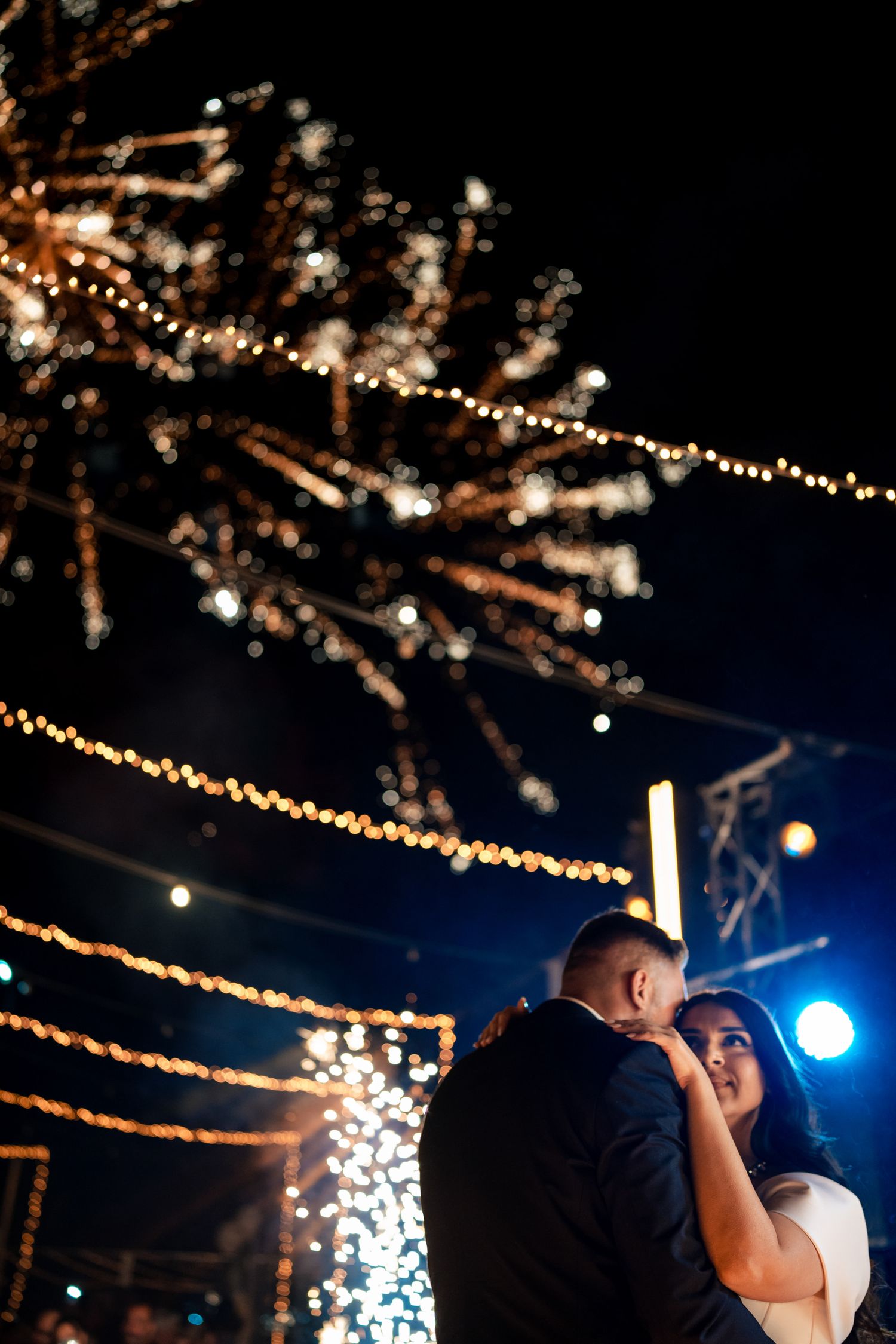 Wedding reception dance under twinkling string lights creating a magical outdoor atmosphere.