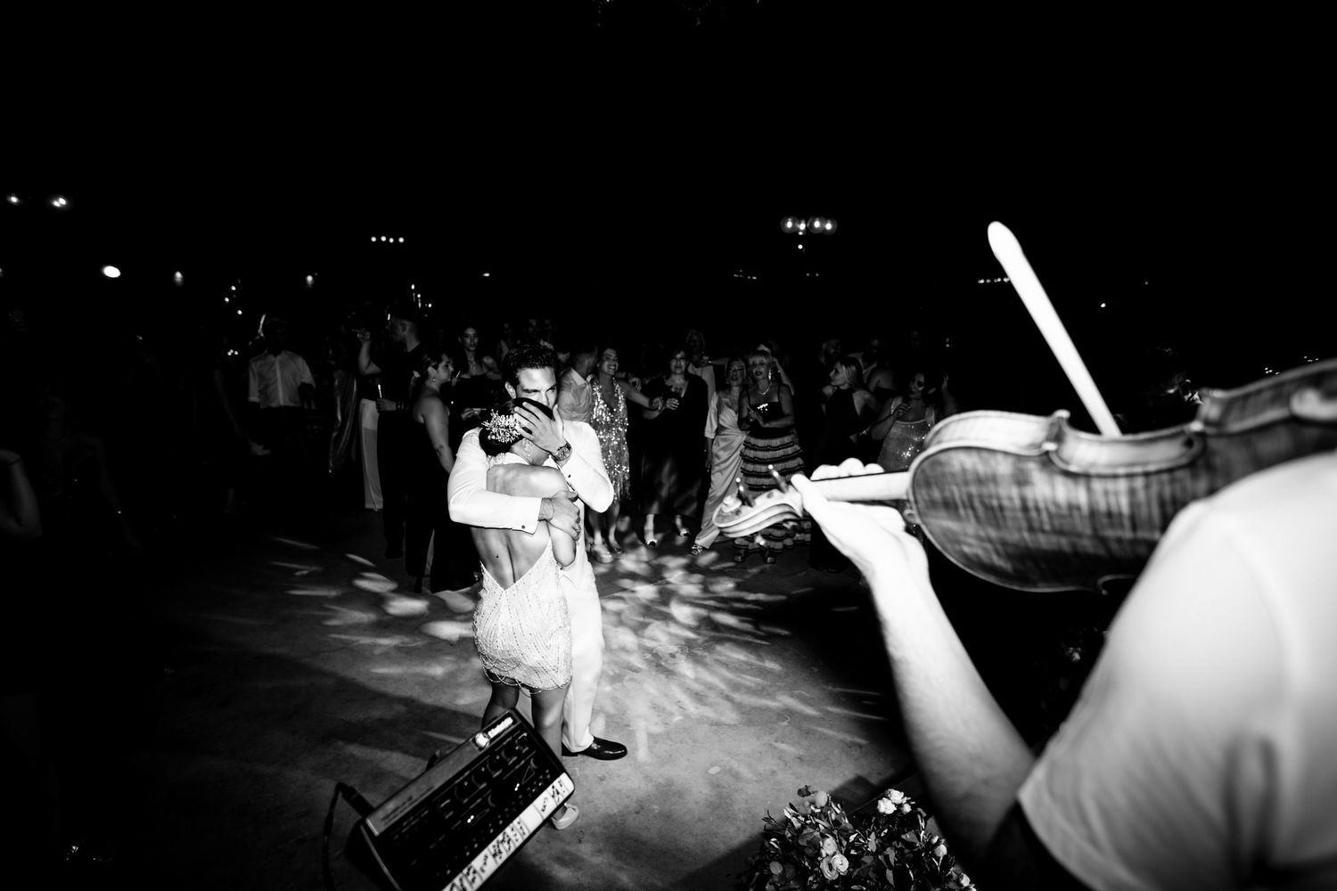 Black and white wedding reception dance floor with guests celebrating in motion blur.