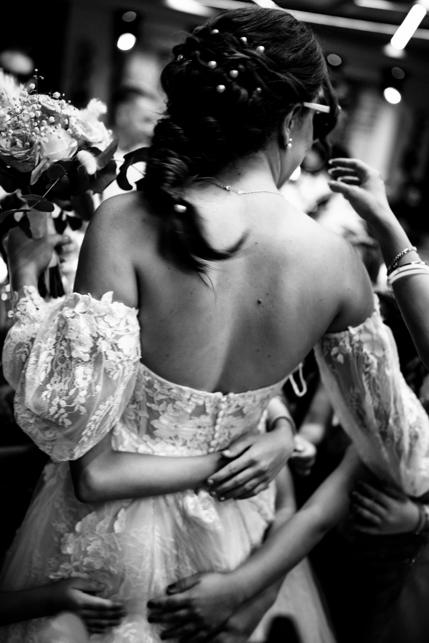 Elegant lace wedding dress details captured in black and white during a dance.