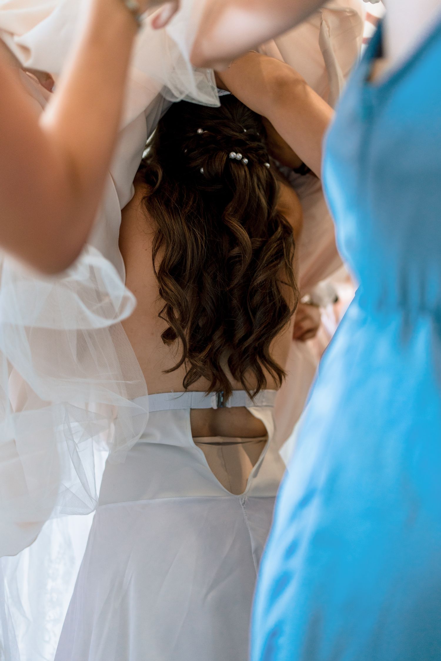 Wedding party detail shot showing white and light blue dresses in a row.