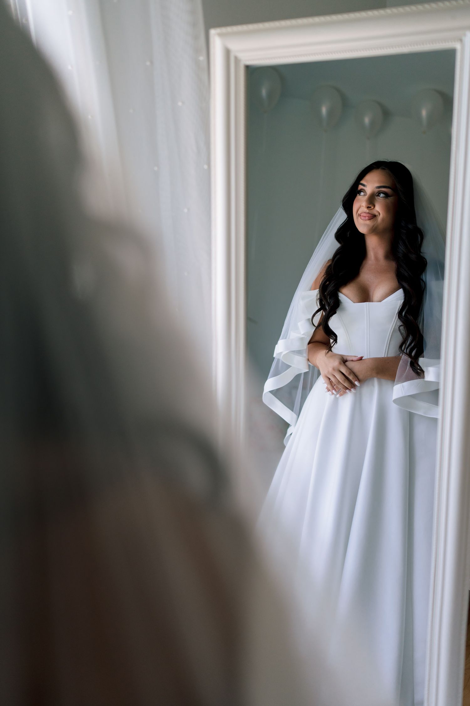 Ethereal bridal portraits in white dress against light interior walls.