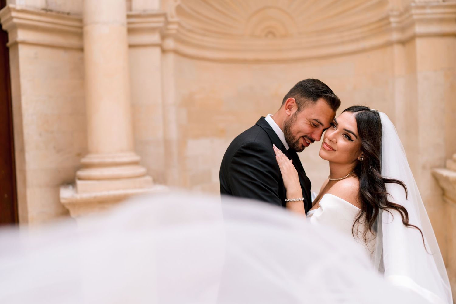 Intimate wedding portraits captured in an elegant white columned gallery.