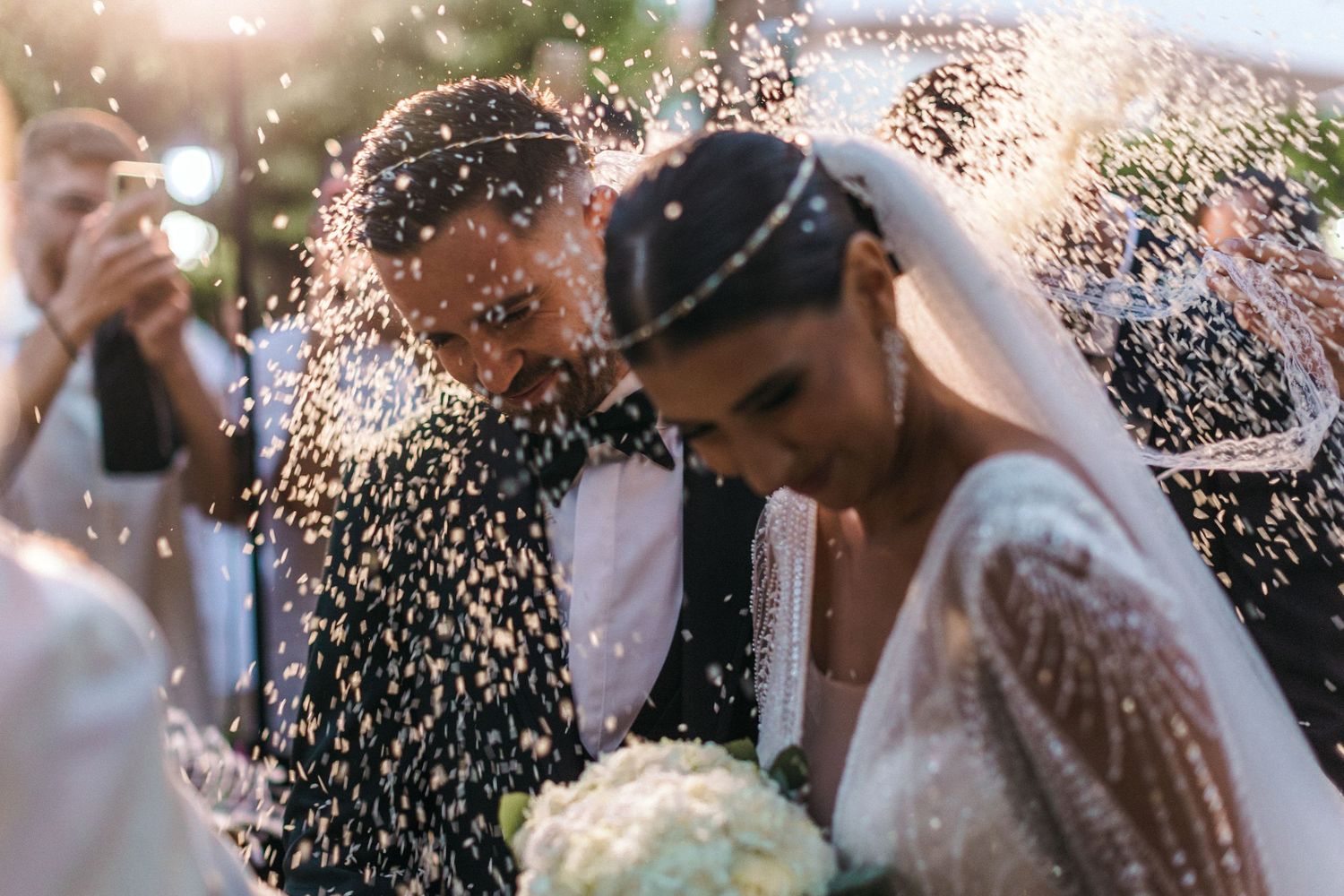 Wedding guests celebrating with confetti and sparklers during an outdoor evening celebration.