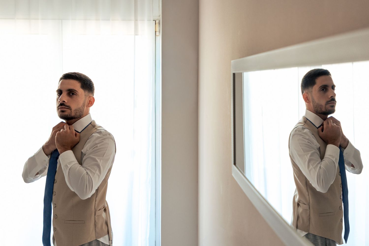 Elegant formal attire being adjusted in a bright room with natural lighting.