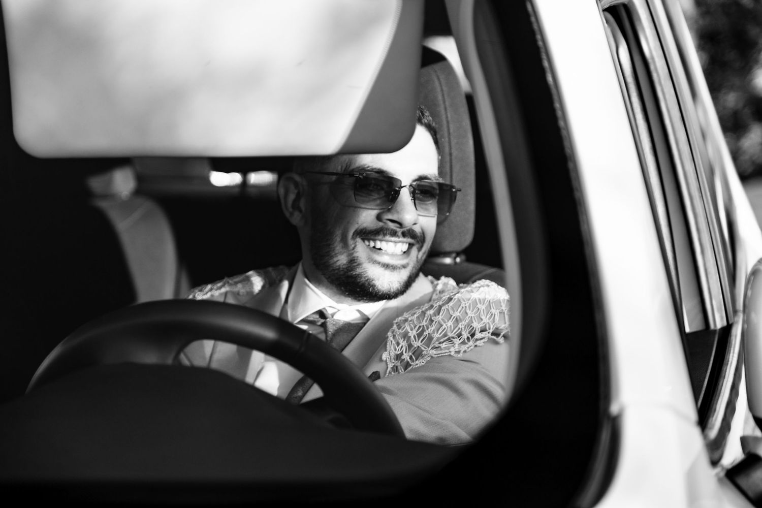 Wedding party traveling in cars with joyful expressions and celebratory atmosphere.
