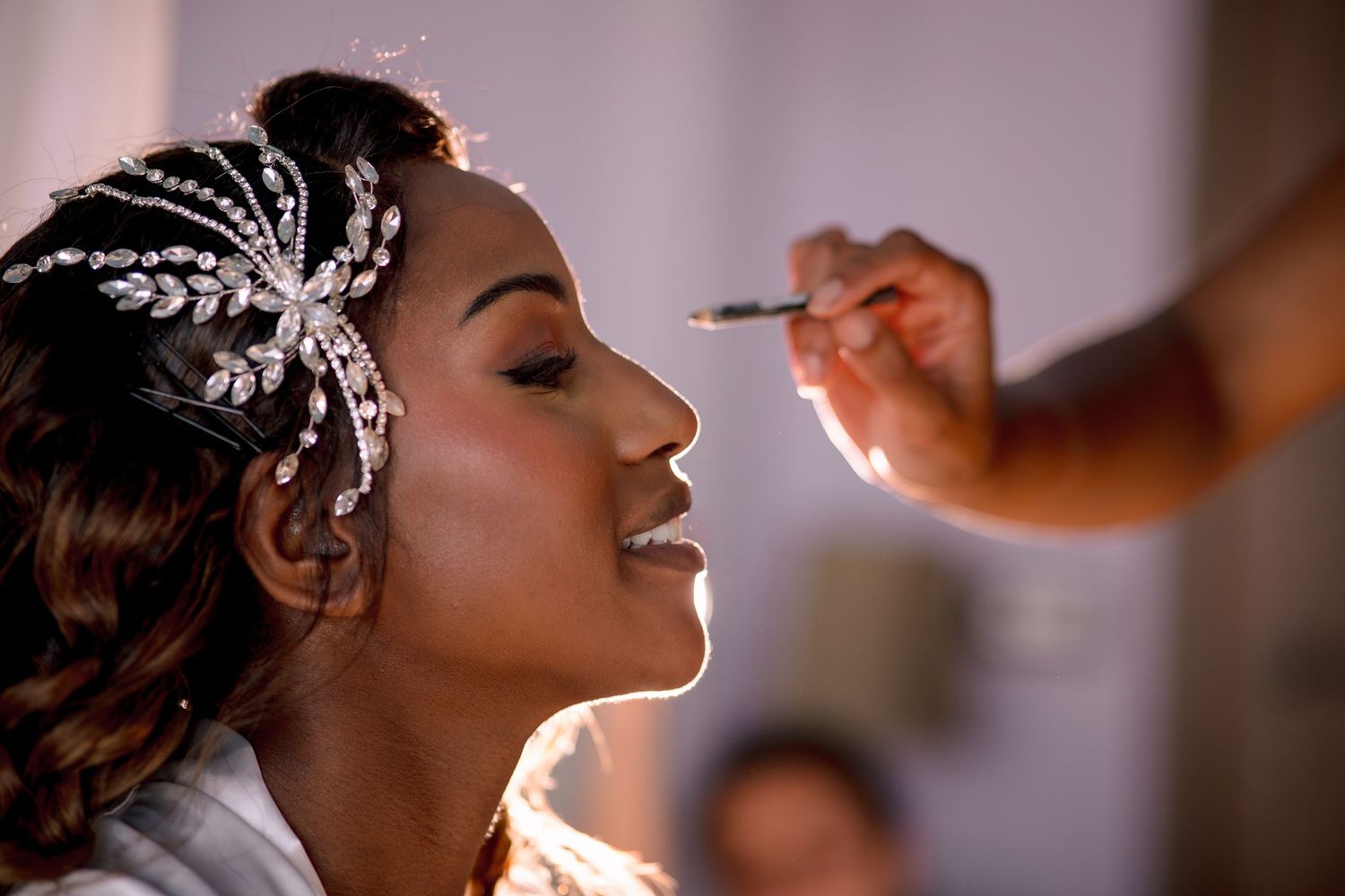 Close-up sequence of professional makeup application with decorative hair accessories.