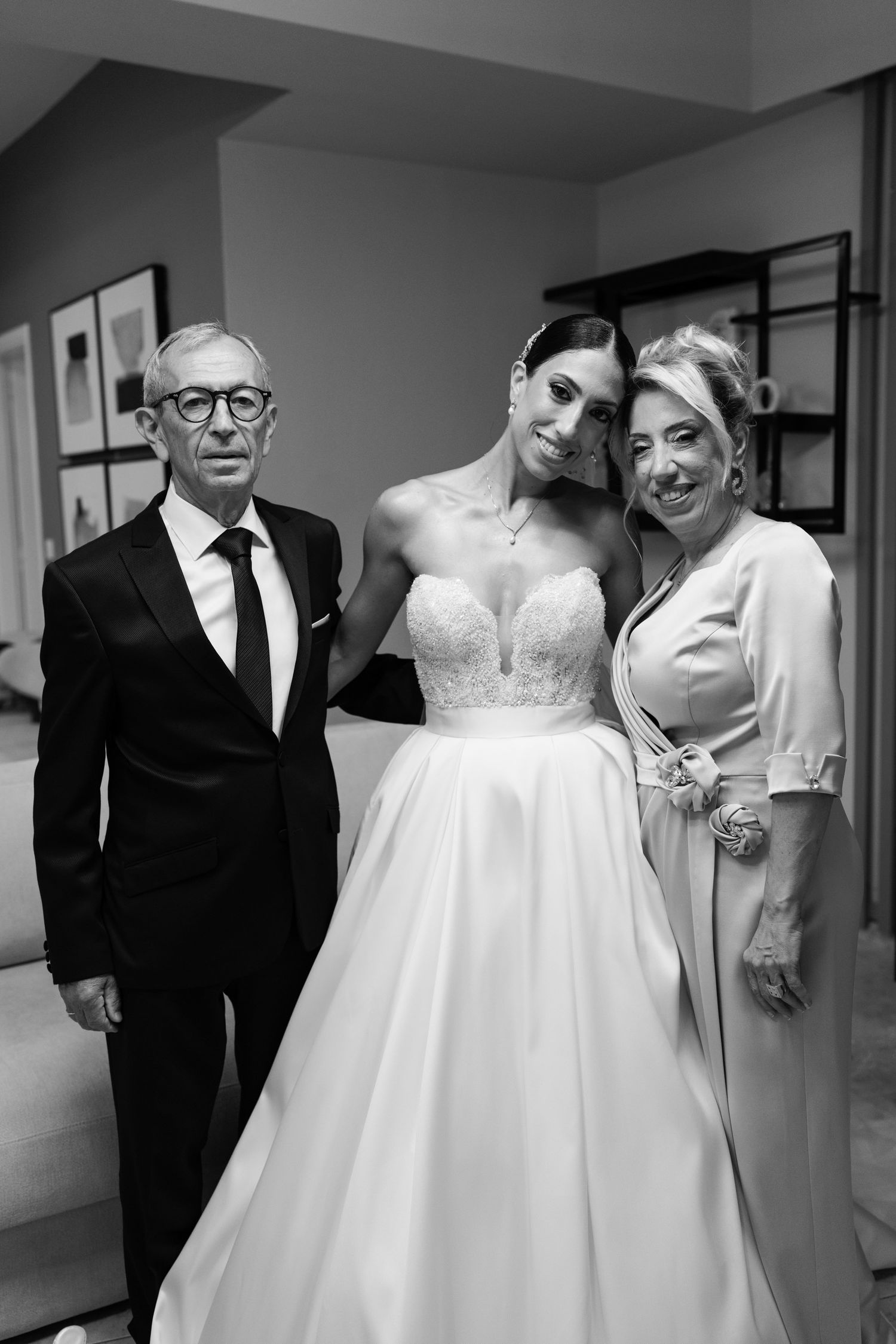 Black and white photo of wedding preparations with bride in ballgown.