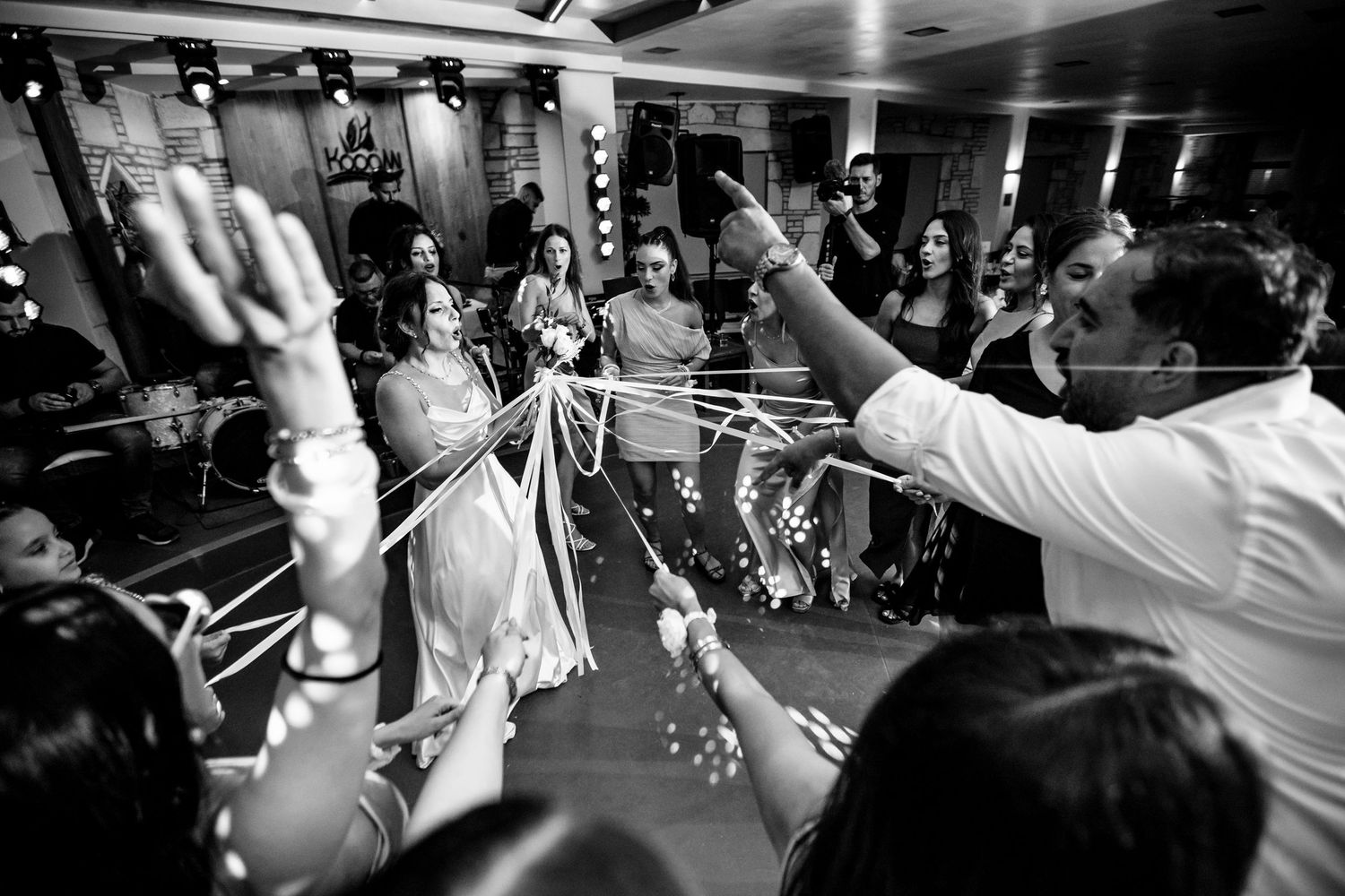 Black and white photo of energetic dancing at a wedding reception.