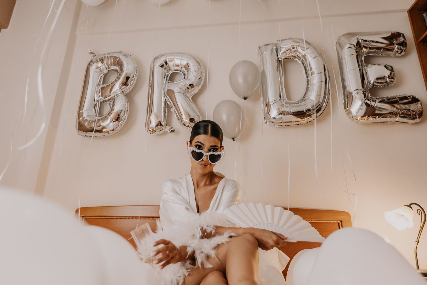 Silver metallic balloon letters decorating a white wall for wedding celebrations.