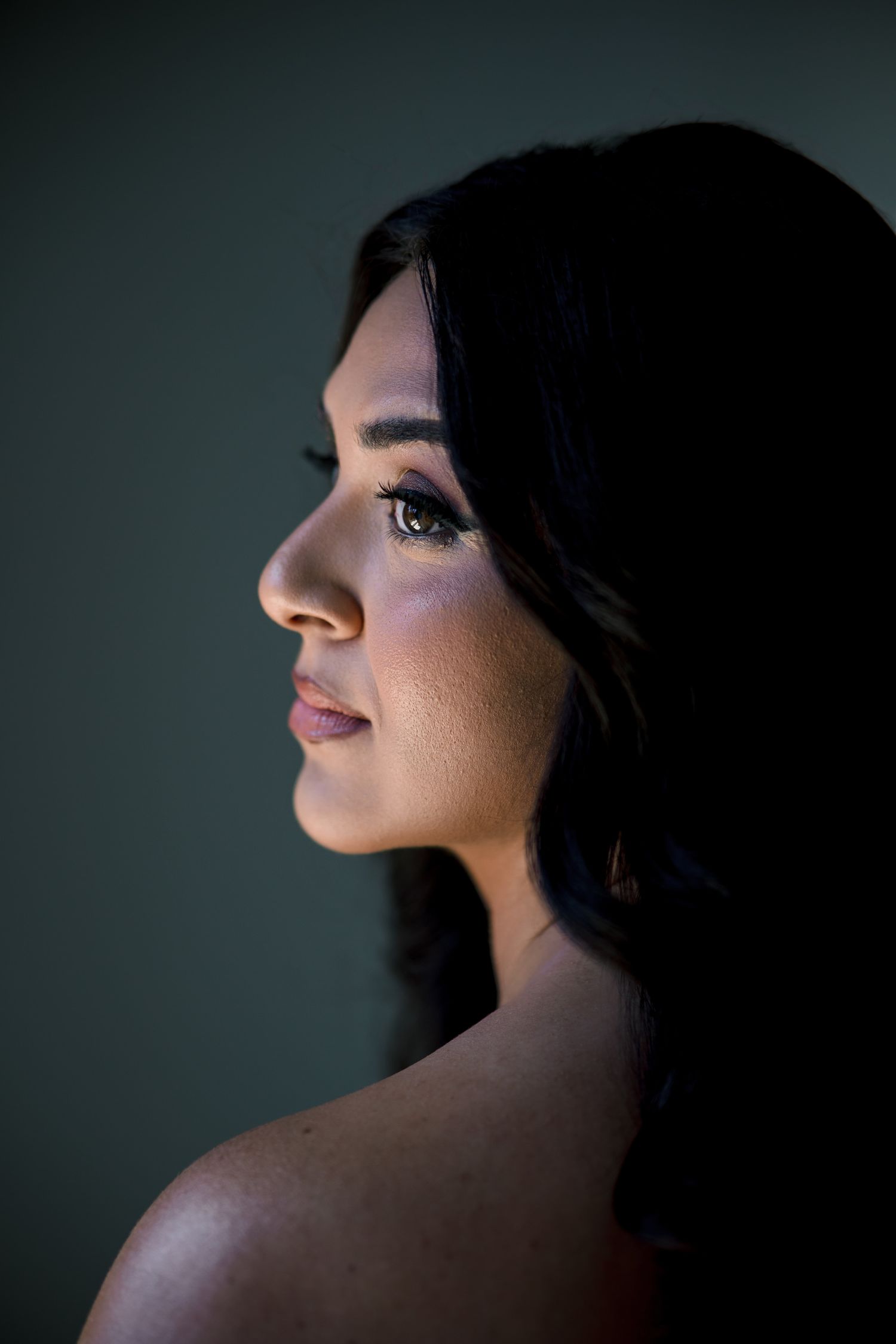 Artistic portrait series showing dramatic side profile lighting against dark background.