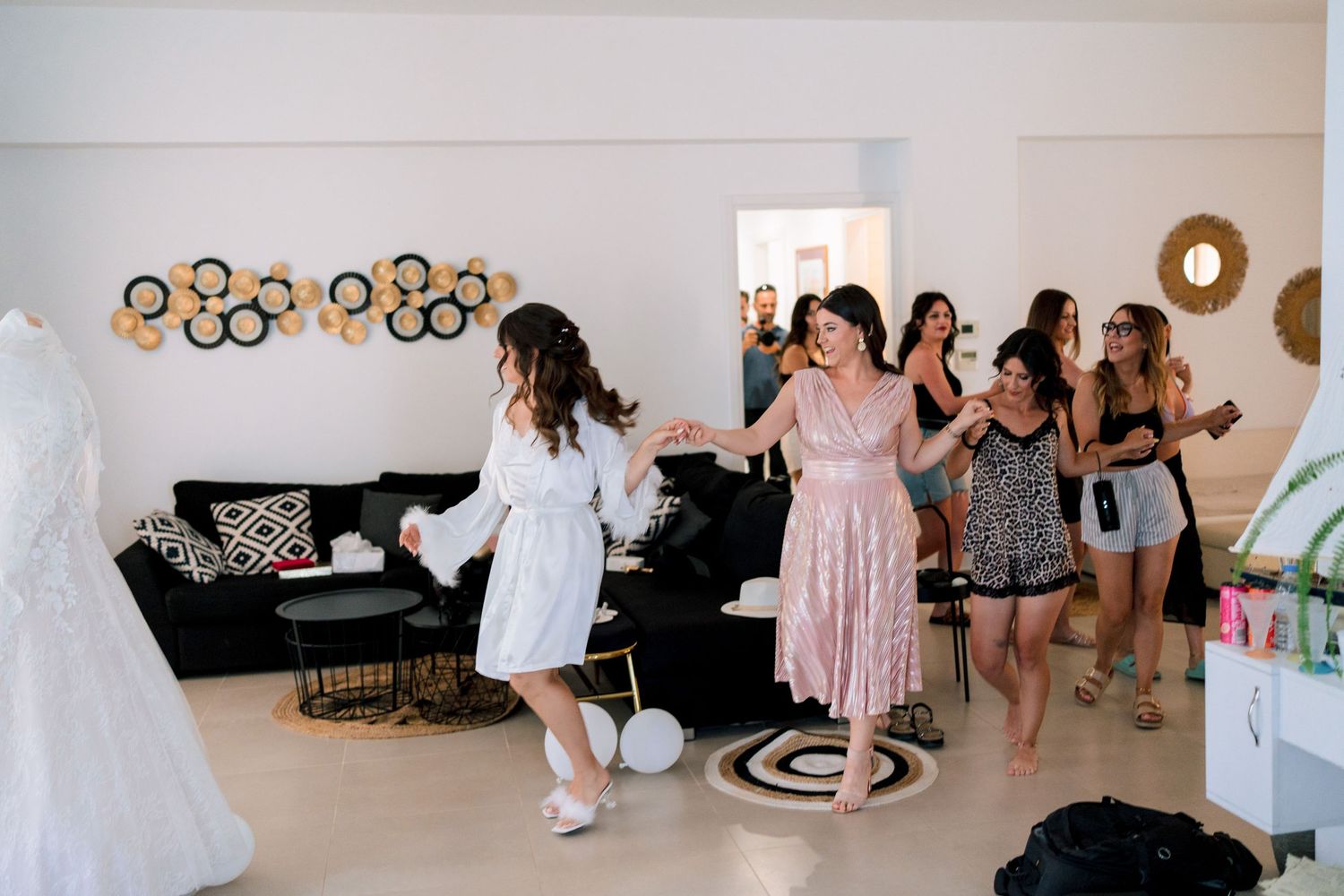 Group of people gathered in a bright room wearing various dresses and outfits.