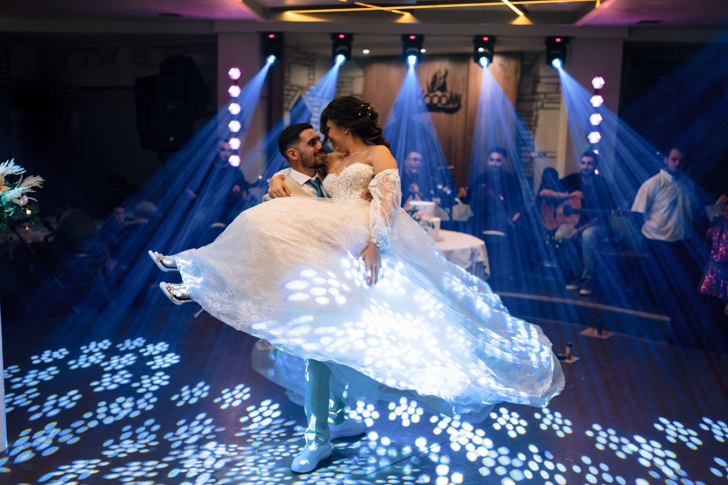 Wedding dance floor illuminated with projected flower patterns and blue lighting effects.