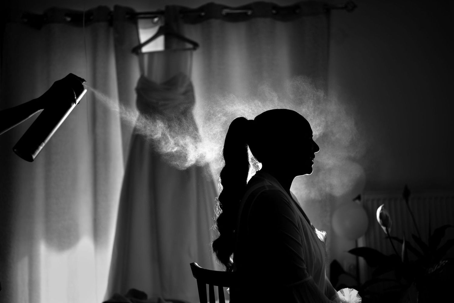 Dramatic silhouette photography of styling preparation against window light.