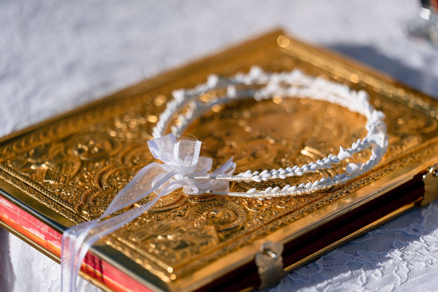 Ornate golden religious book or bible with decorative cover and cross details.