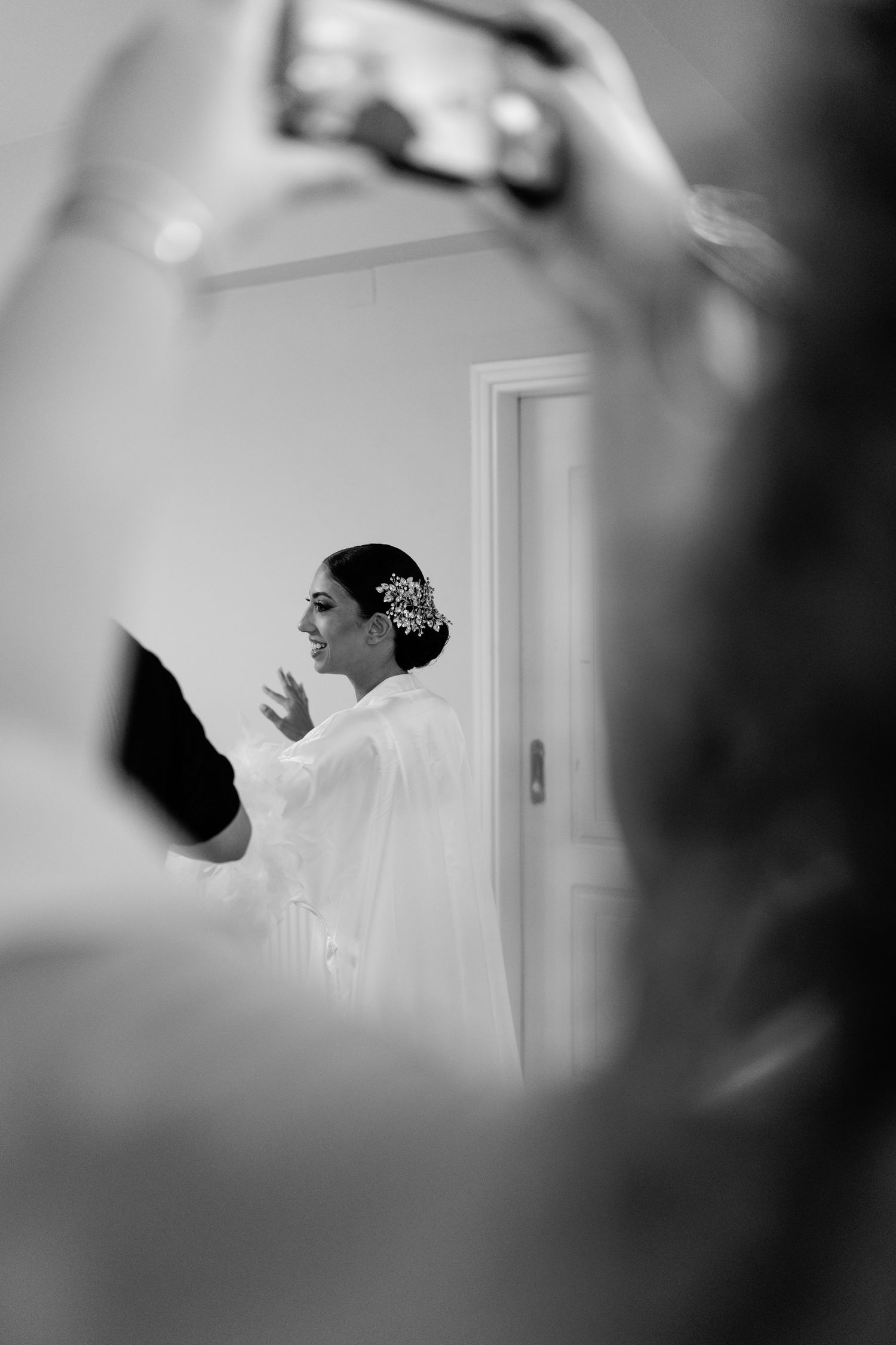 Black and white image of wedding preparations captured through a mirror reflection.