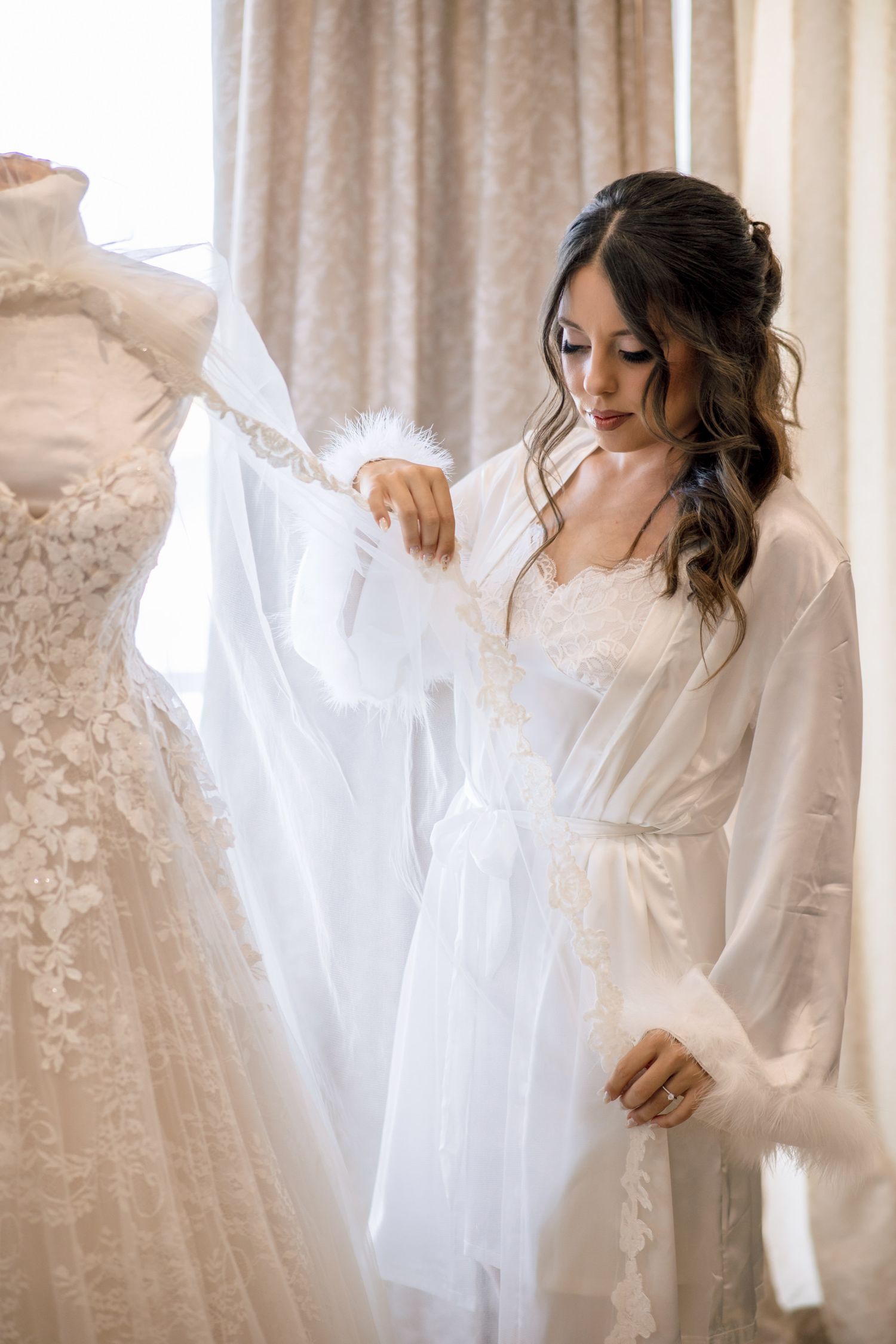 White wedding gowns hanging on display with delicate lace details.
