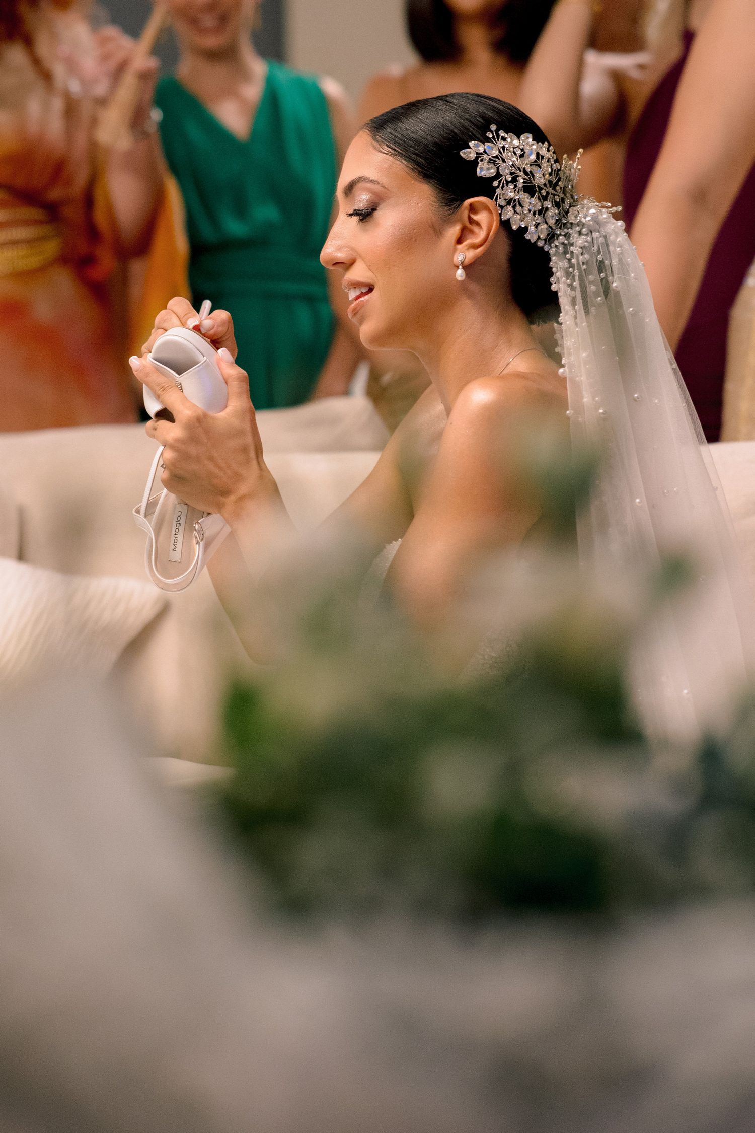 Close-up details of a bride wearing an ornate crystal headpiece and white gown.