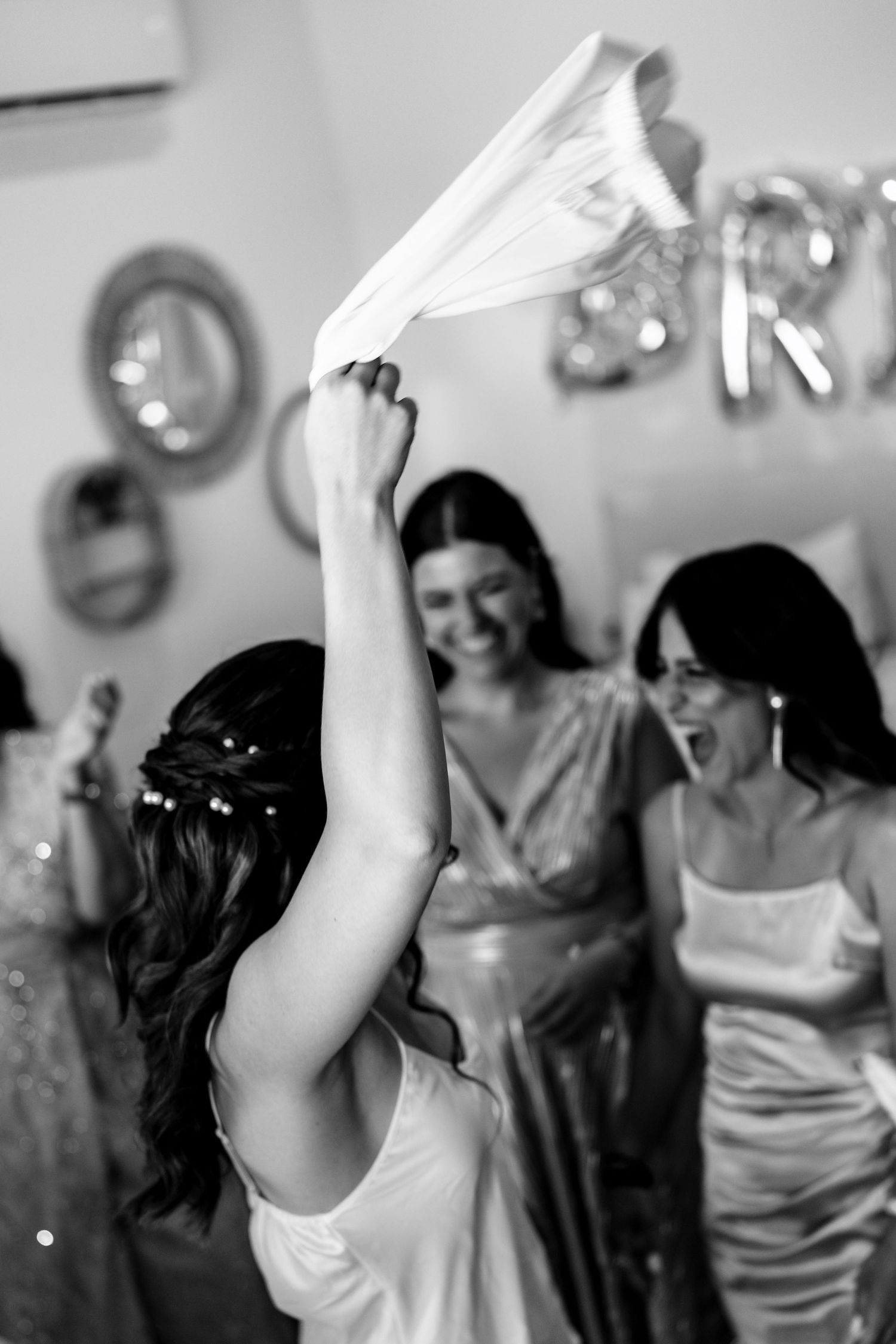 Bridesmaids celebrating joyfully with napkins in the air.
