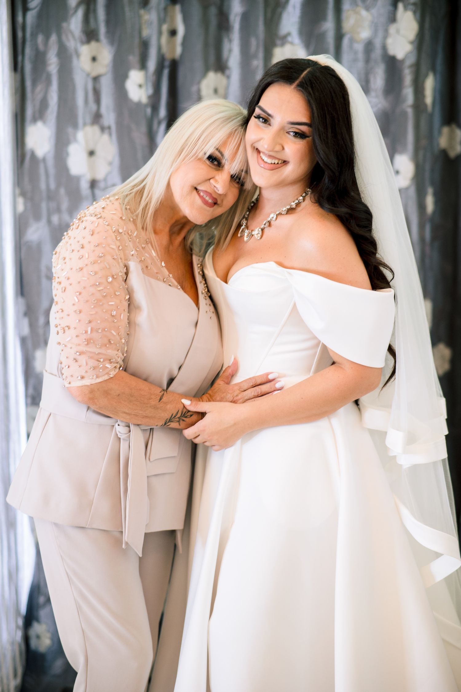Joyful embrace between two people in elegant formal attire.