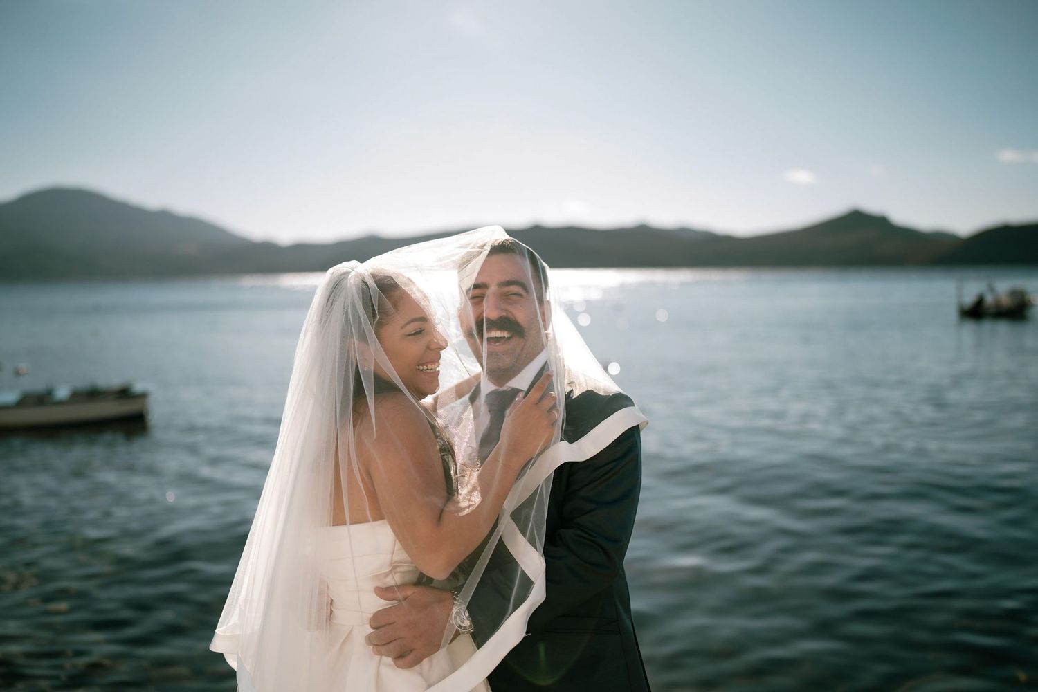 Romantic waterfront wedding photos with mountain landscape and ocean views.