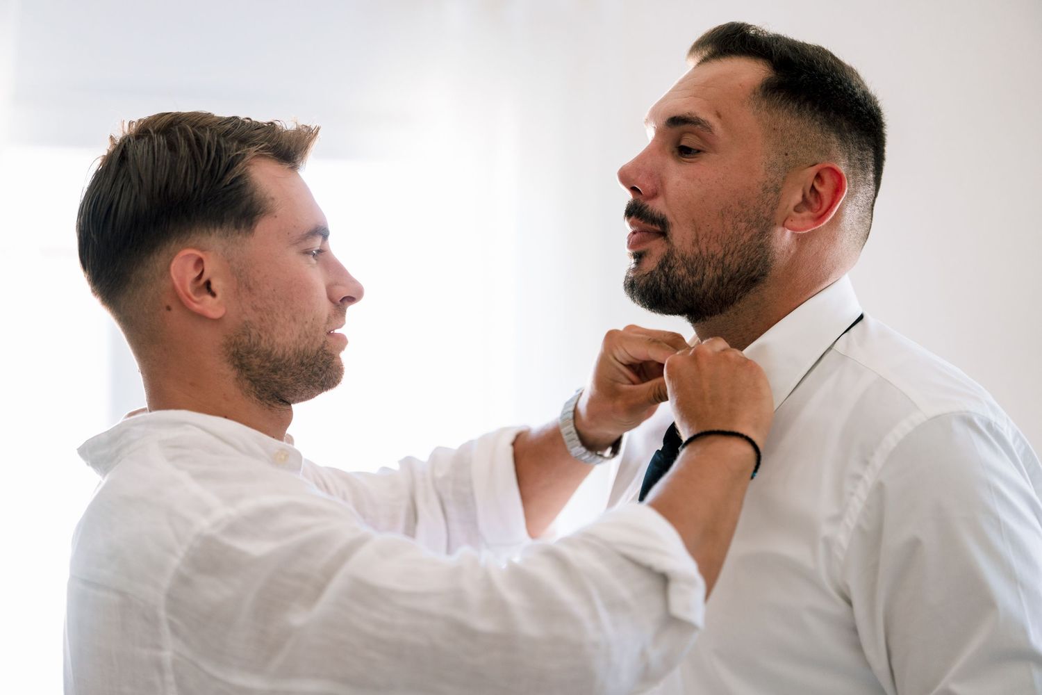 Two people in white shirts having a conversation in a bright room.