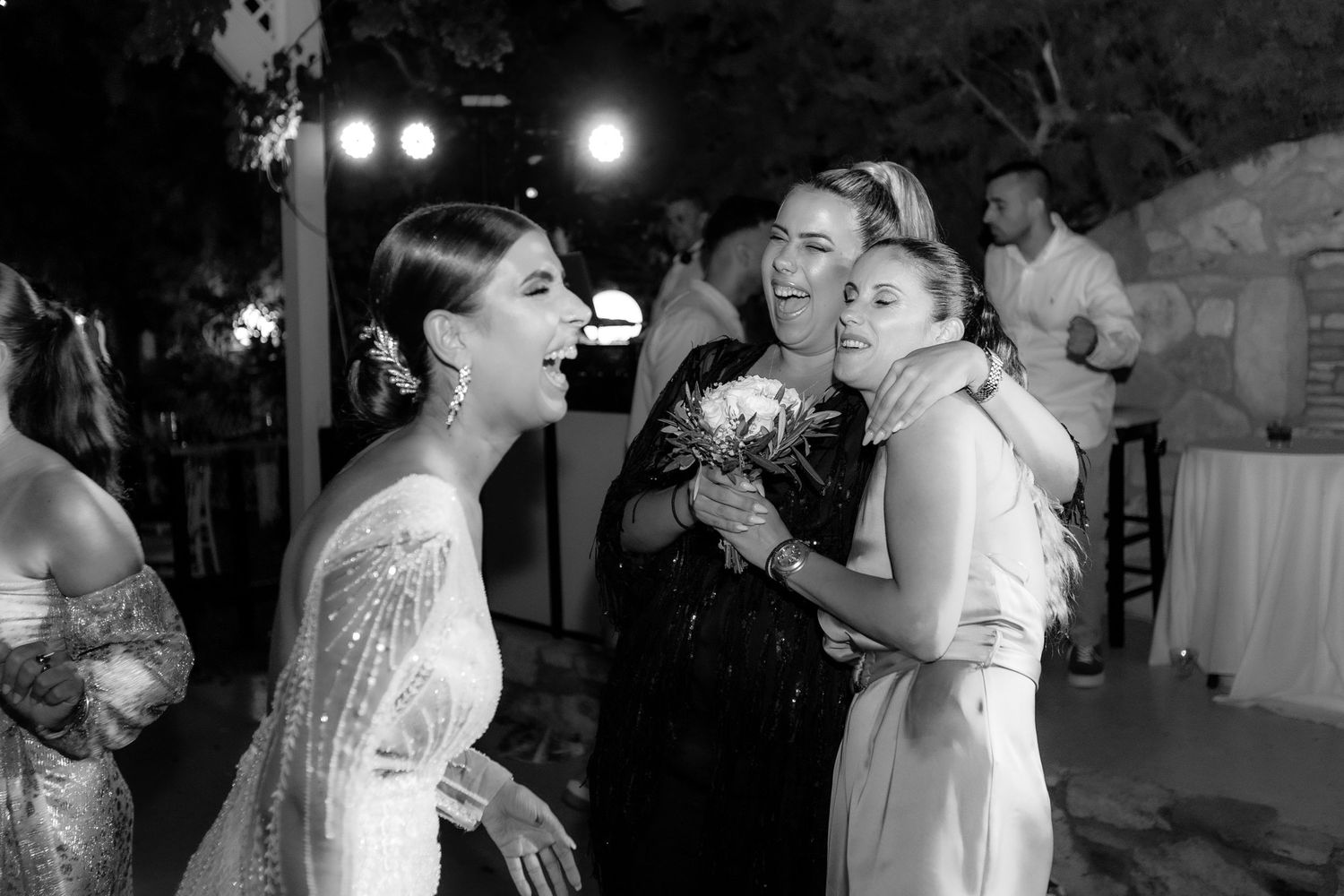 Black and white photo of couples dancing during an intimate wedding reception moment.