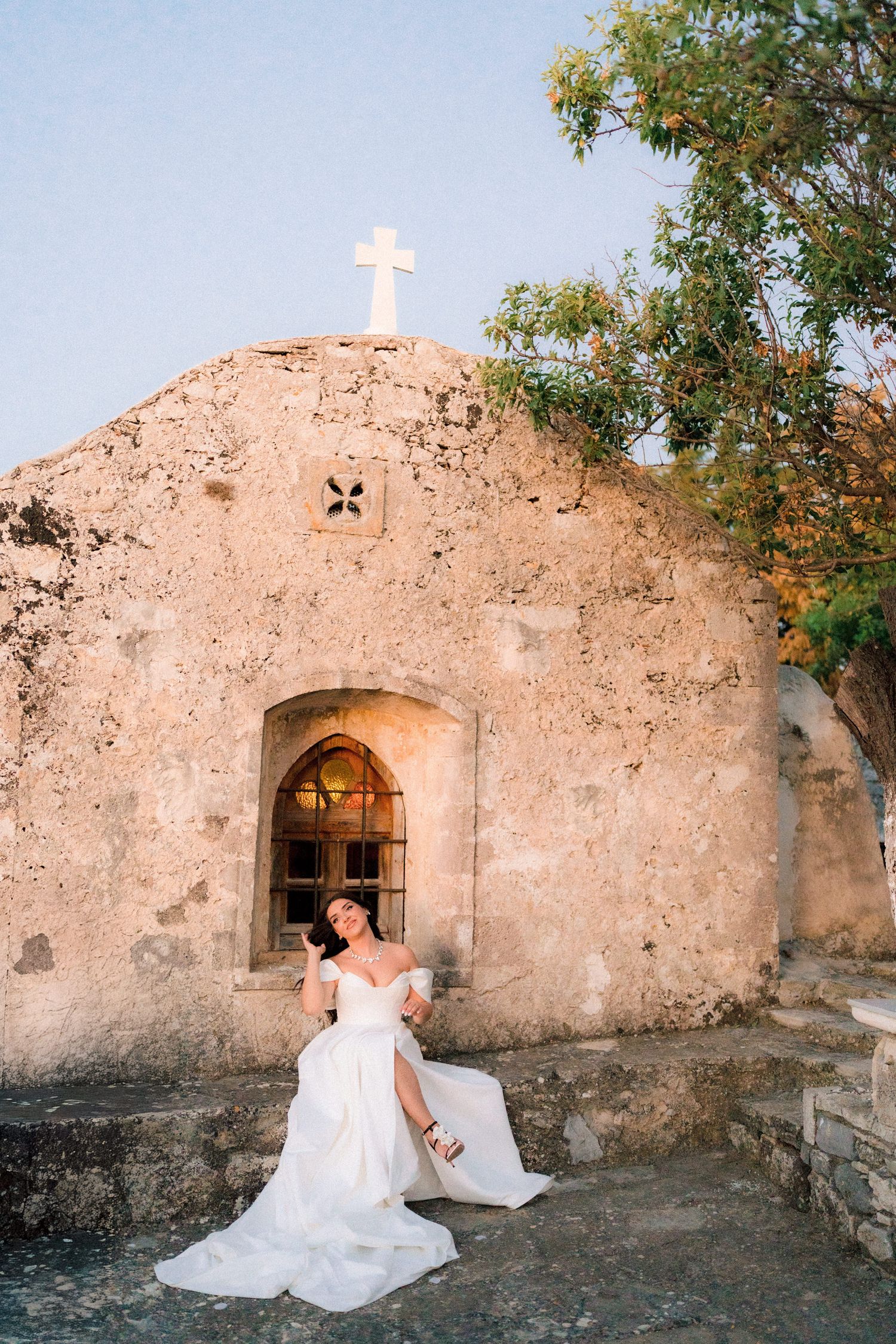 Stone church ruins with cross and archway provide romantic wedding photo backdrop.