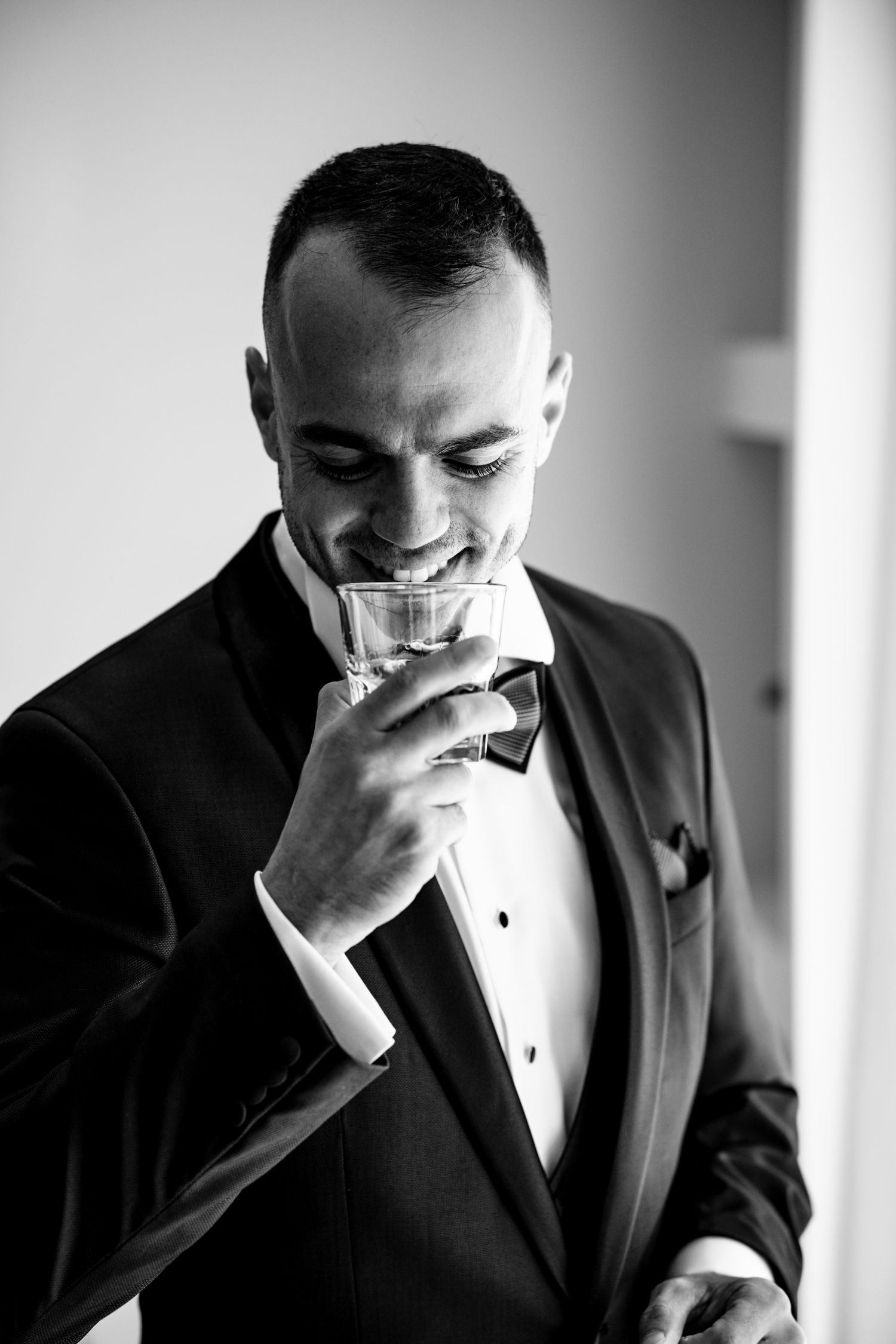 Black and white emotional moments of a groom preparing for his wedding ceremony.
