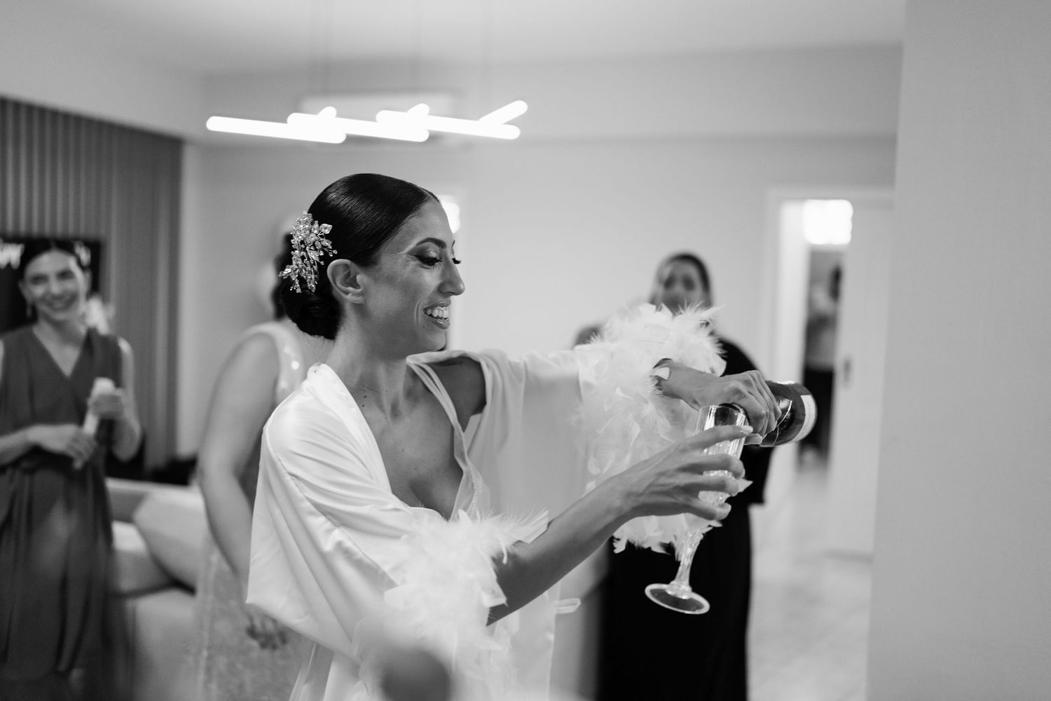 Wedding party toasts with champagne glasses during pre-ceremony celebrations.
