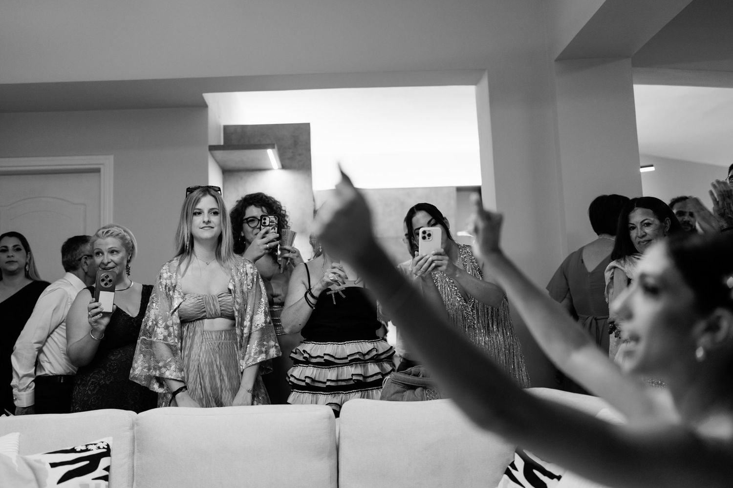 Wedding guests dancing and celebrating in a candid black and white moment.