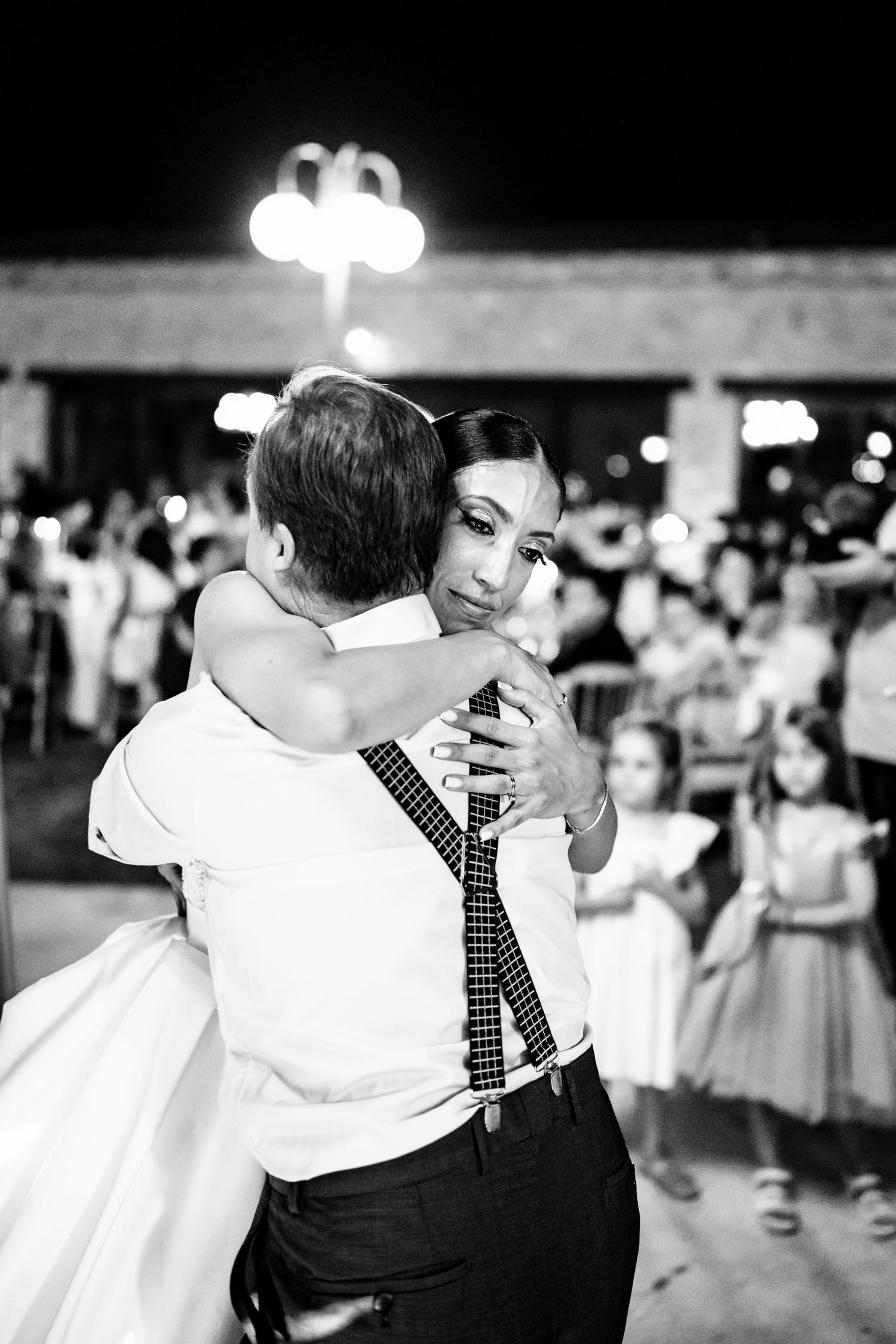 Black and white photo captures tender moment during first dance at wedding reception.