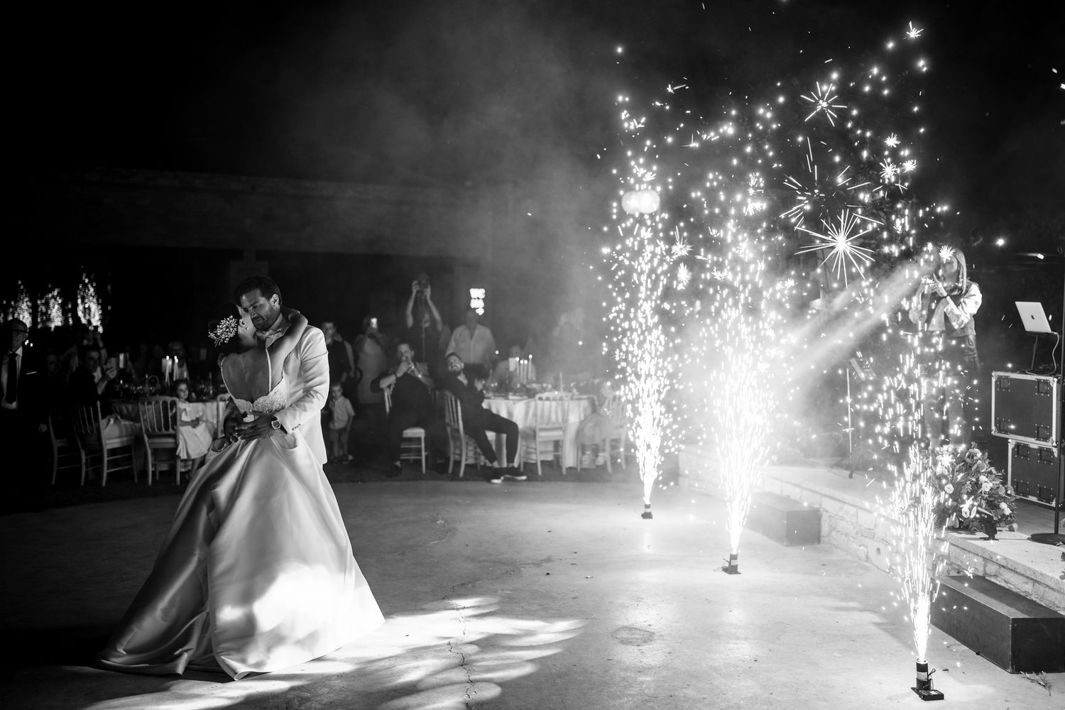 Wedding couple dances as sparklers create magical light effects on the dance floor.